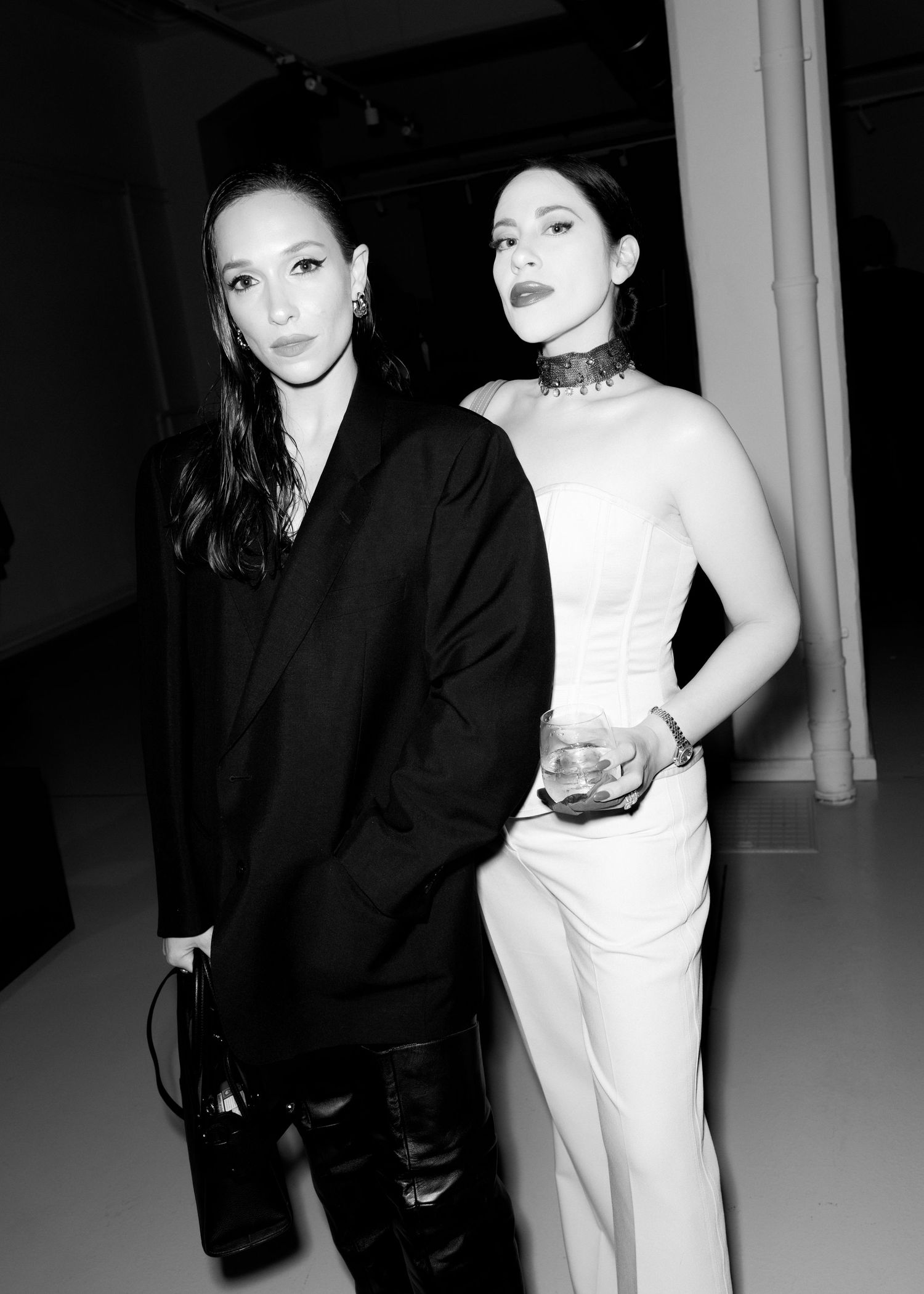 Black and white photo of two people in contrasting black and white formal attire at an event.
