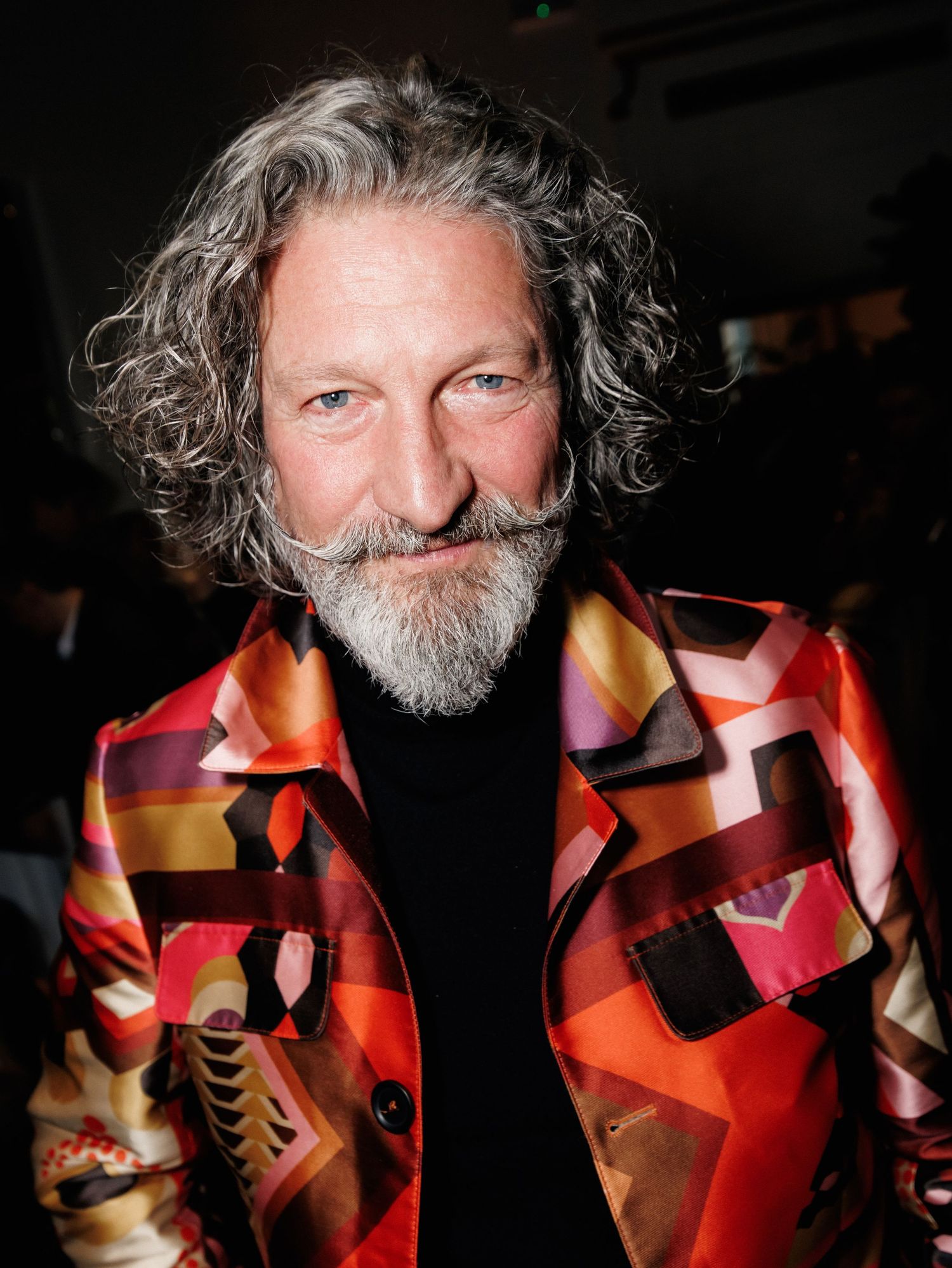 A sequence of close-up shots showing a red geometric patterned shirt or jacket design against a dark background.