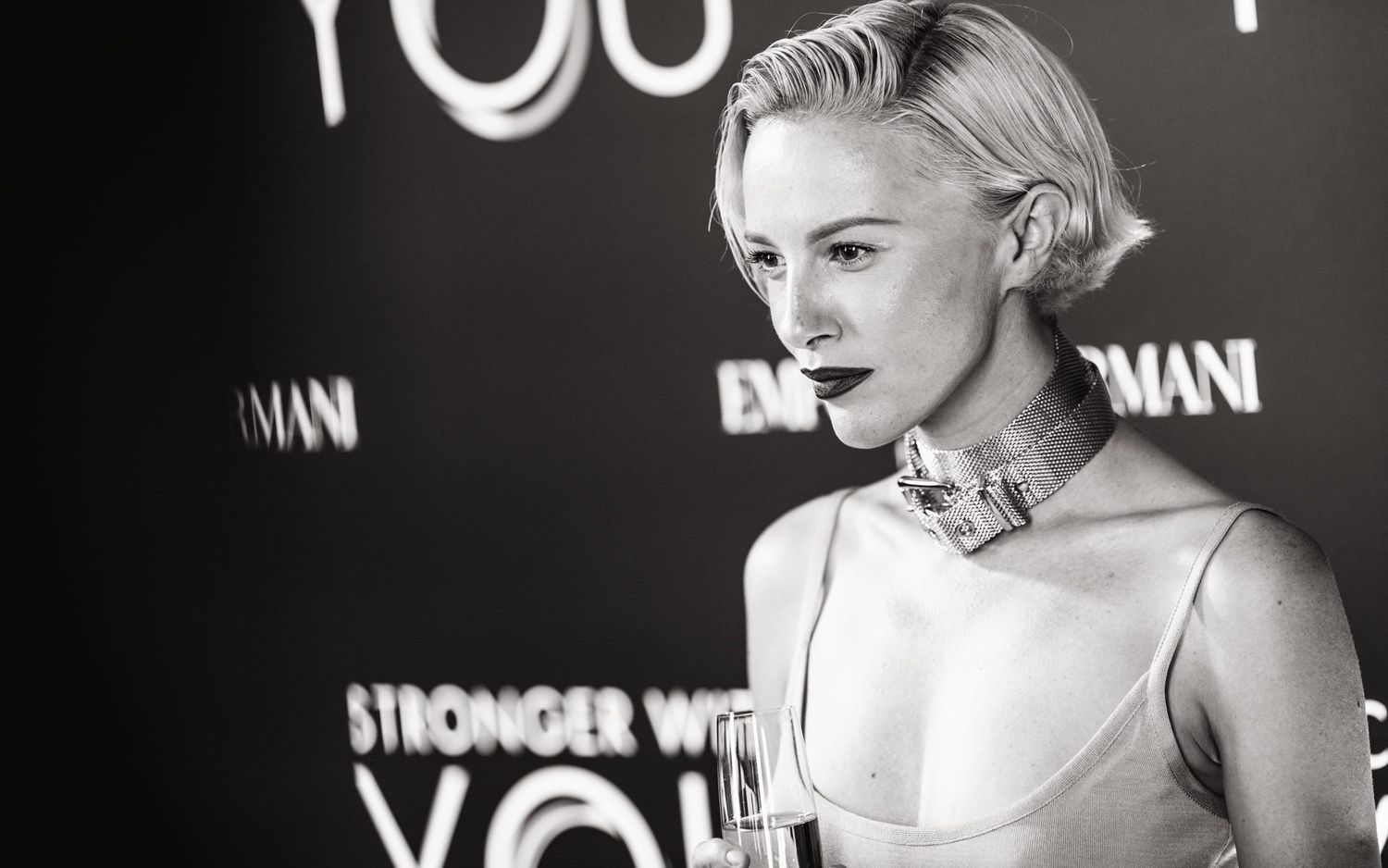 Black and white portrait against illuminated backdrop at formal event.