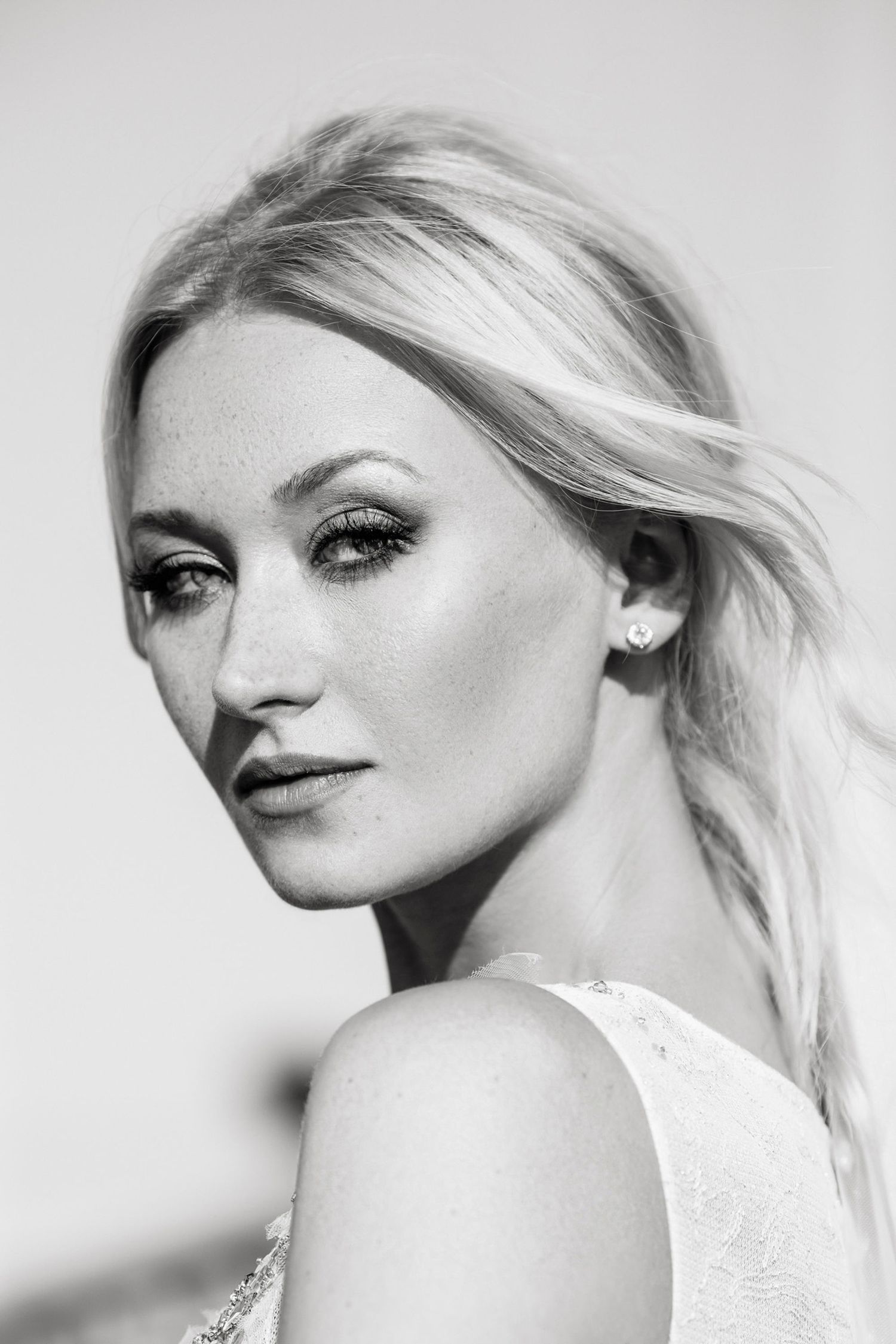 Elegant portrait of a woman with blonde hair in black and white.