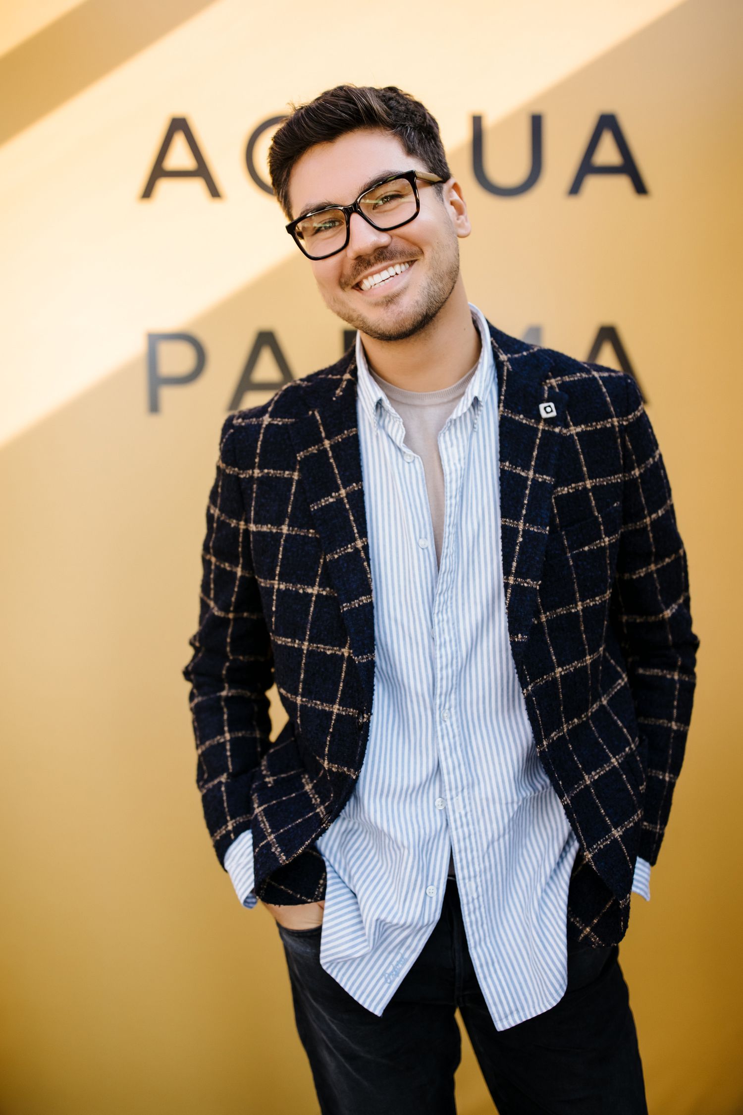 Casual fashion portrait against beige wall with text reading Acqua Palma.