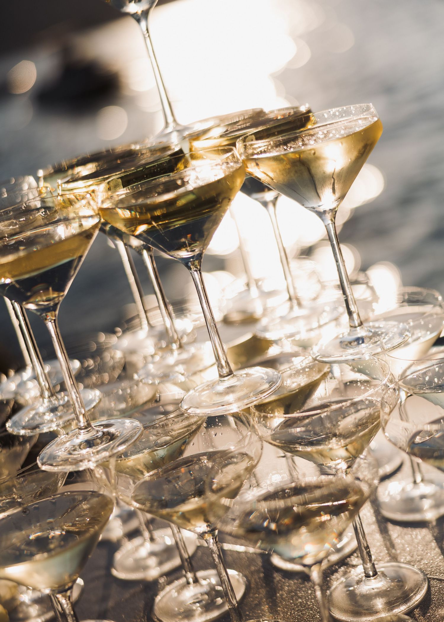 Champagne tower with golden bubbles cascading through crystal glasses in elegant celebration setting.