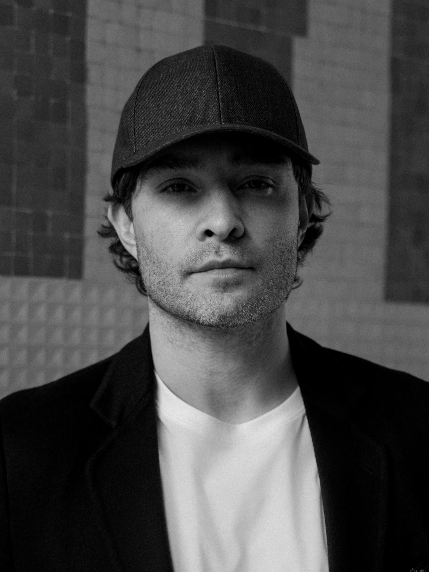 A black and white portrait series showing a person wearing a dark cap and white shirt against a shadowy background.