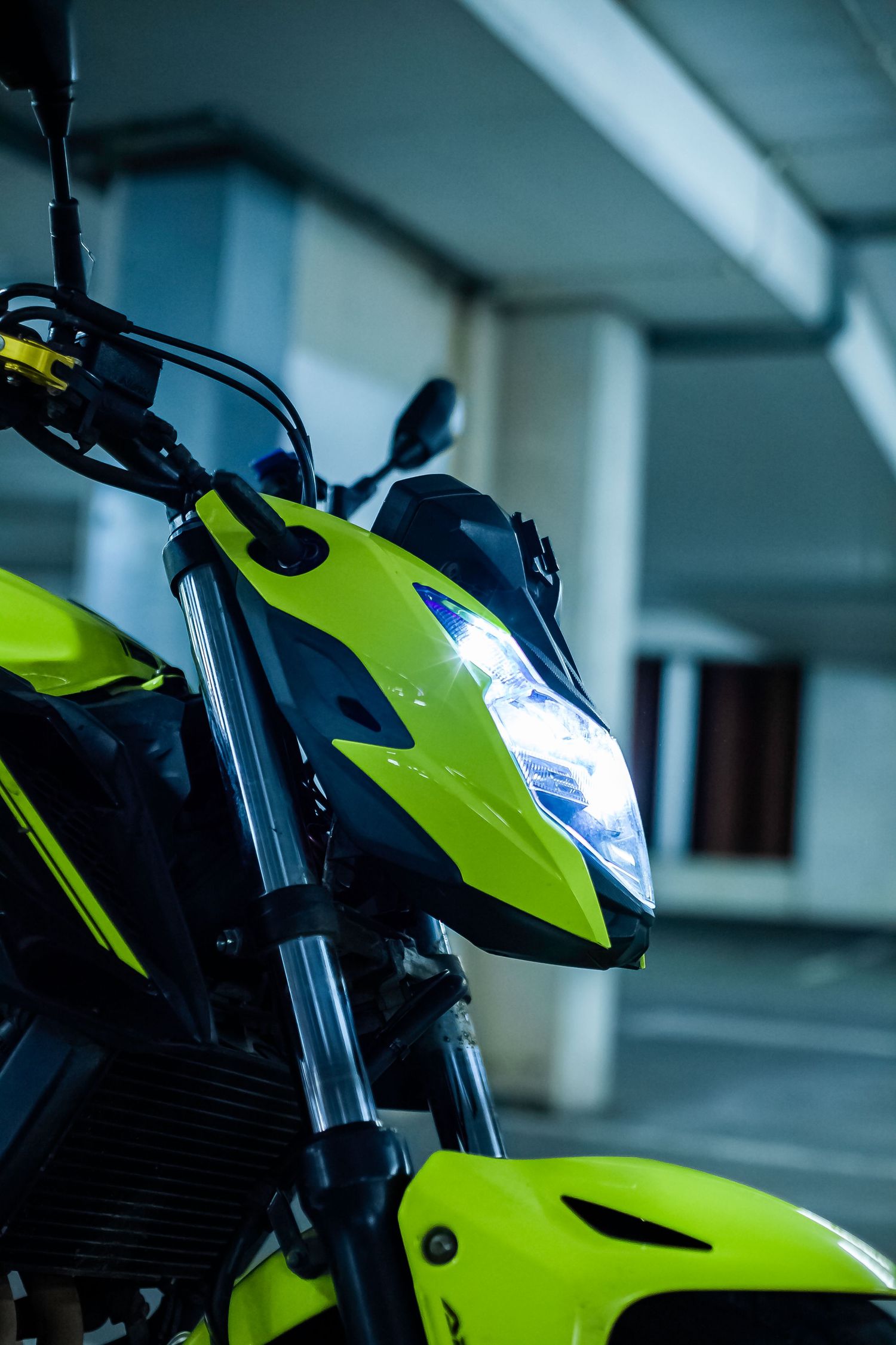 Bright neon yellow motorcycle with sleek modern design parked in an indoor garage setting.