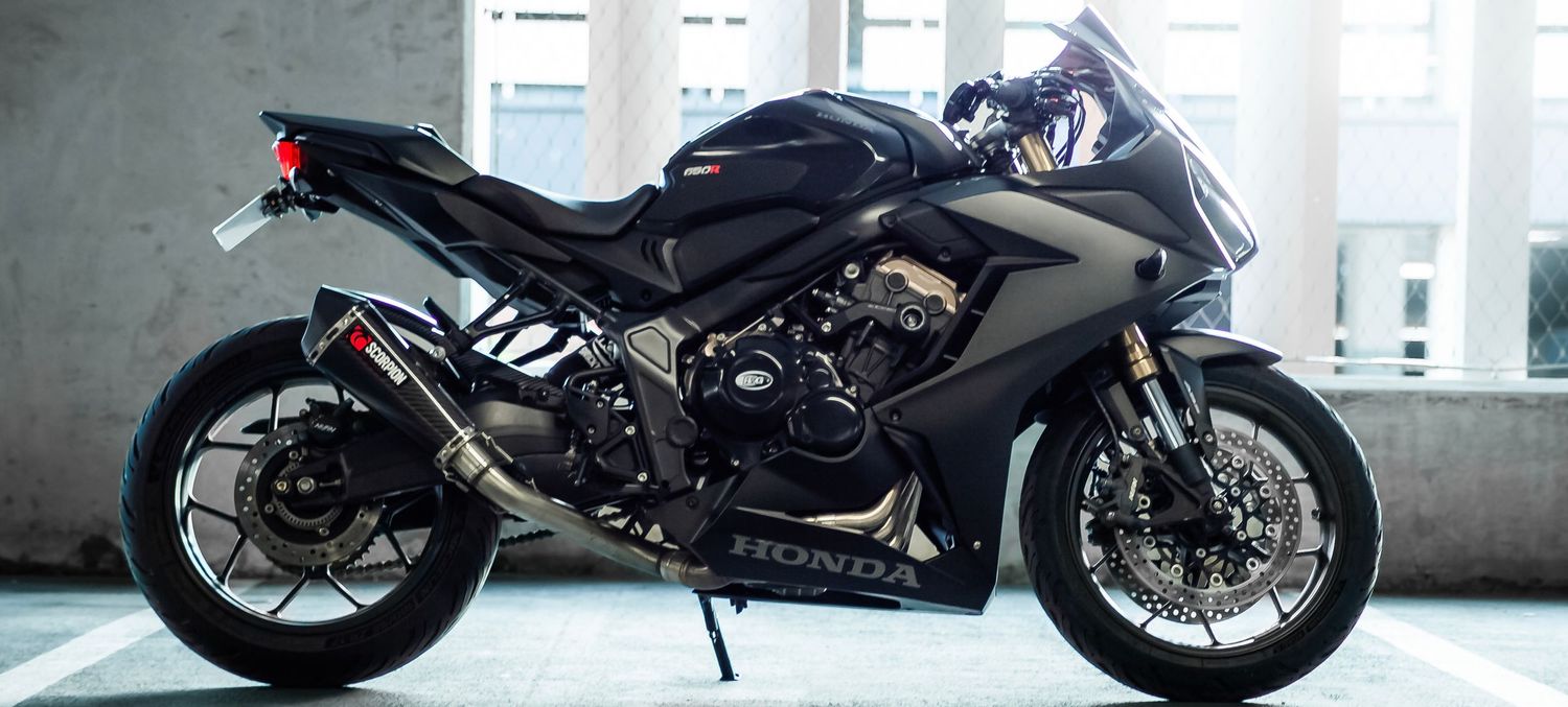 Sleek black Kawasaki Ninja sport motorcycle parked indoors with a modern urban background.