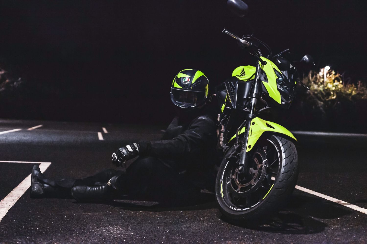 Dark silhouette of a motorcycle illuminated by dramatic lighting at night.