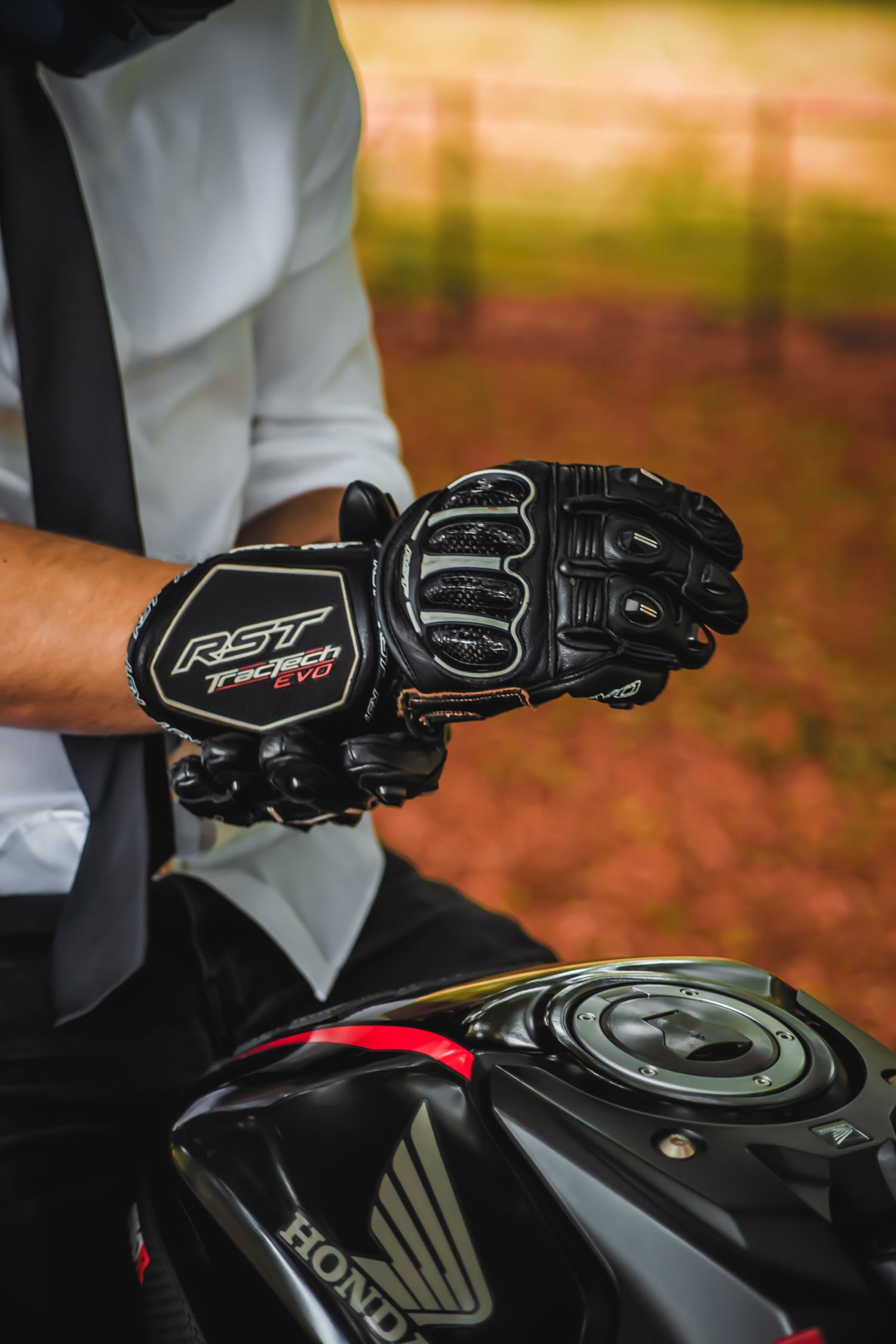 Close-up shots of black motorcycle gloves gripping handlebars and controls.