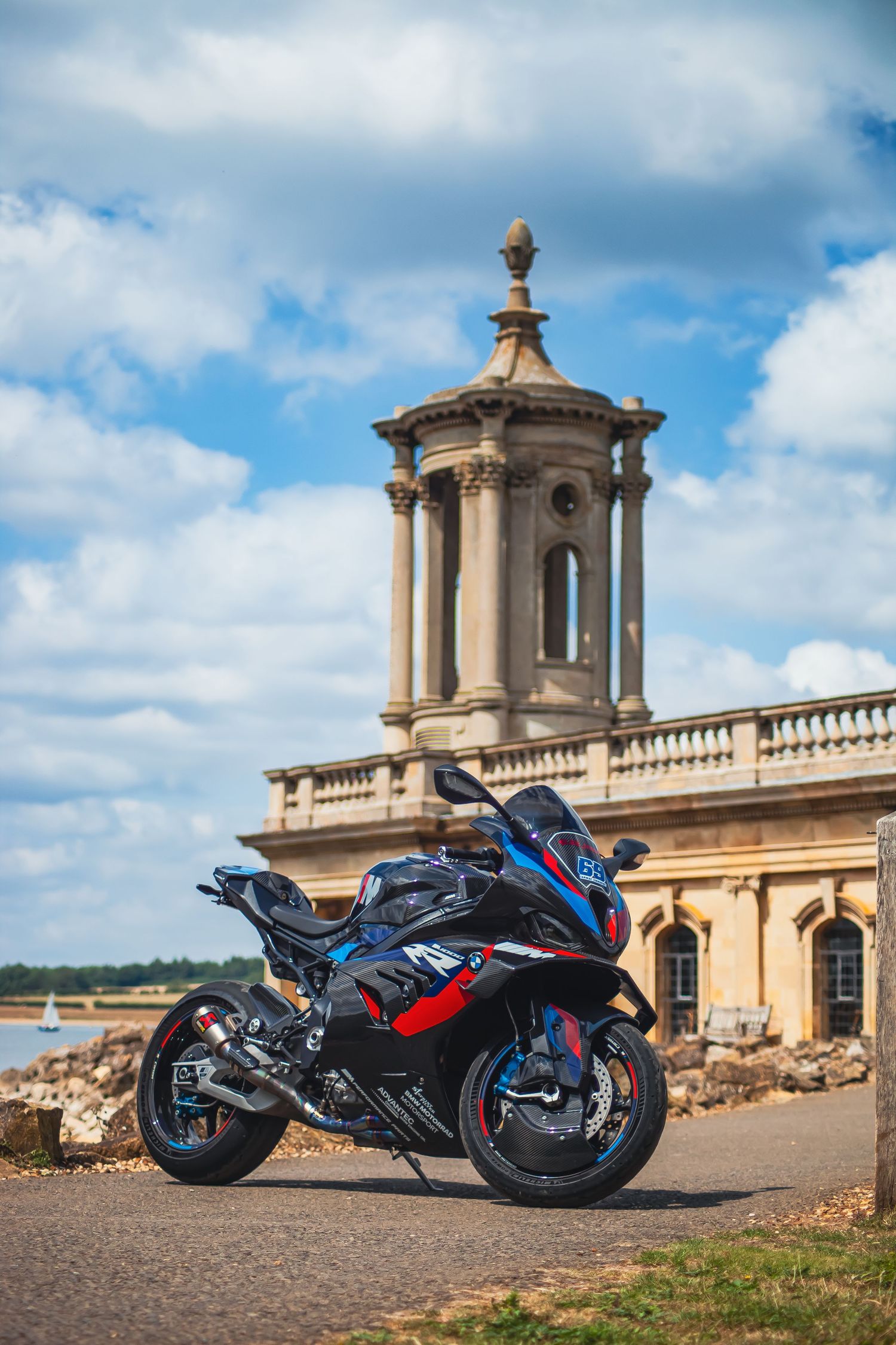 BMW S1000RR superbike parked in front of a historic stone building with classical architecture under cloudy skies.