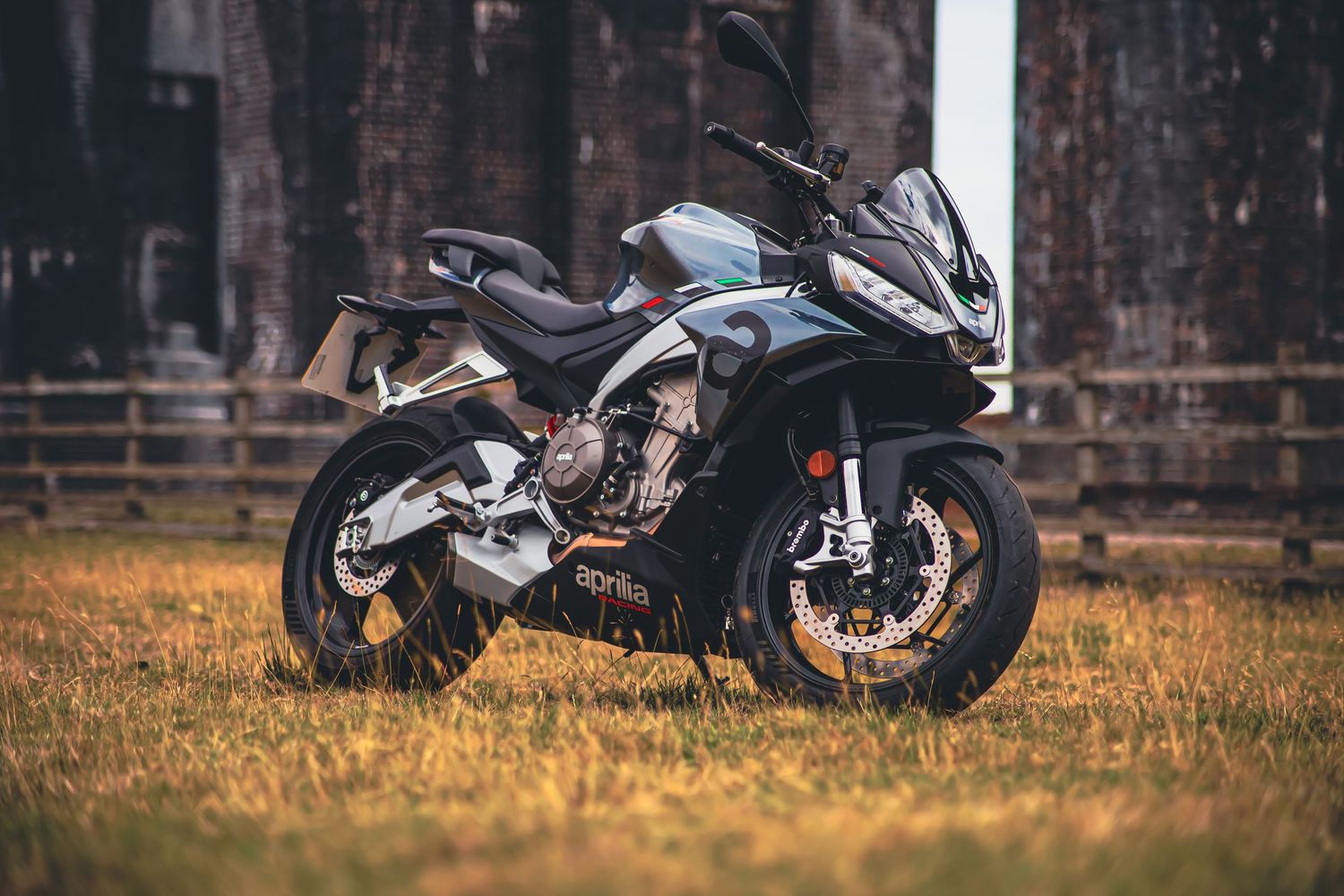 Black sport motorcycle photographed in field with shallow depth of field.