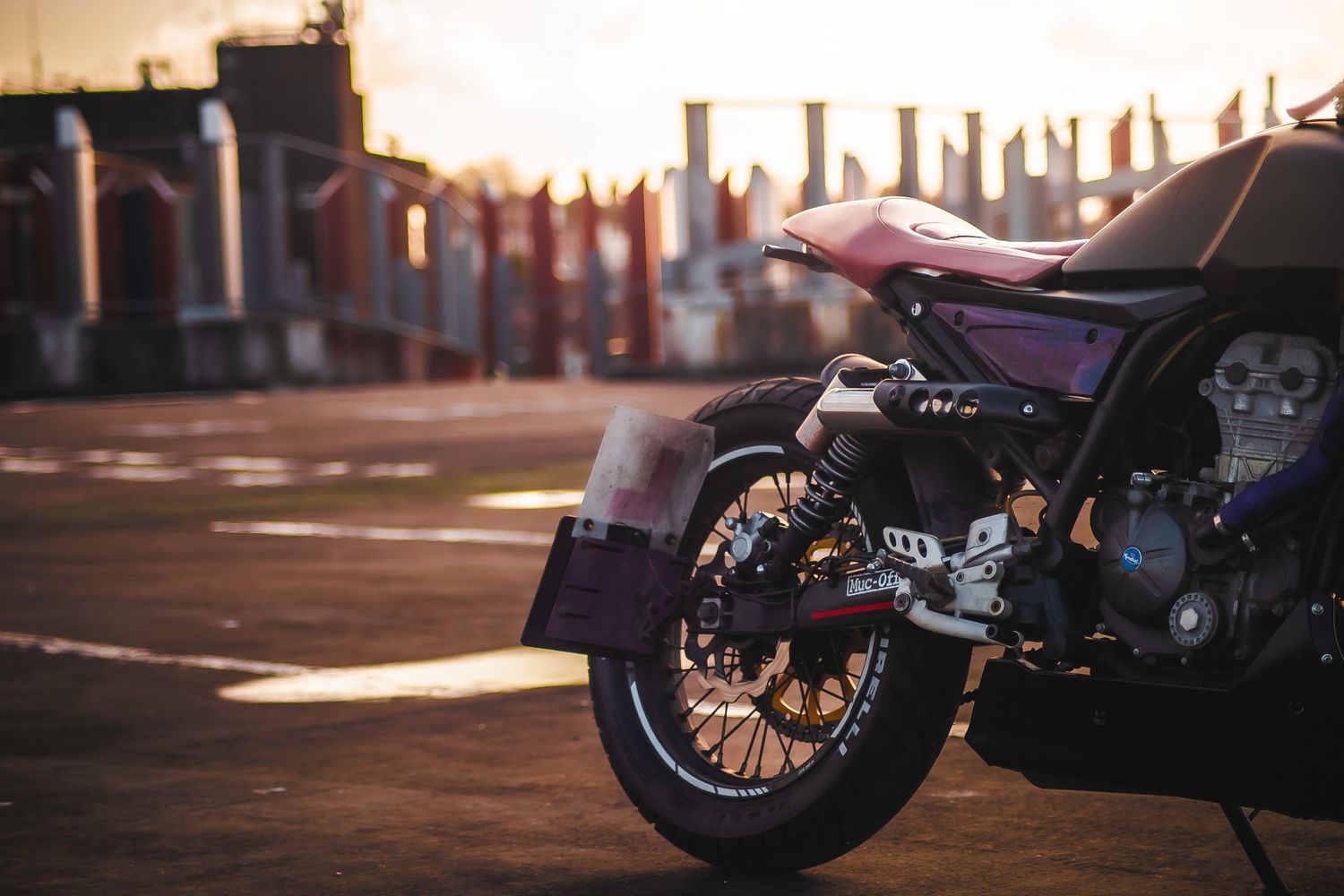 Low angle view of motorcycle silhouettes parked in a row during sunset with dramatic shadows.