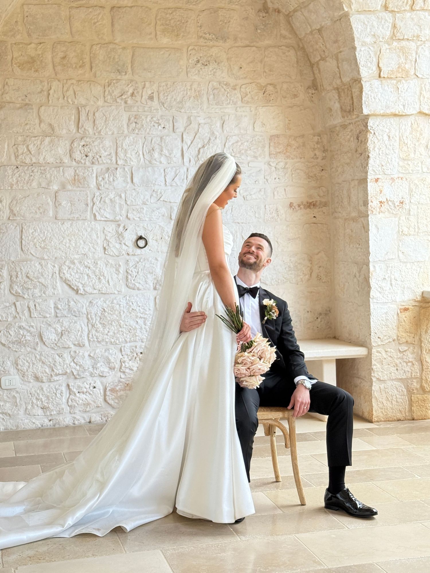 A candid, unposed photo of a bride and groom during their shooting at Masseria Grieco in Ostuni, Puglia. Captured on iPhone by Behind Wed