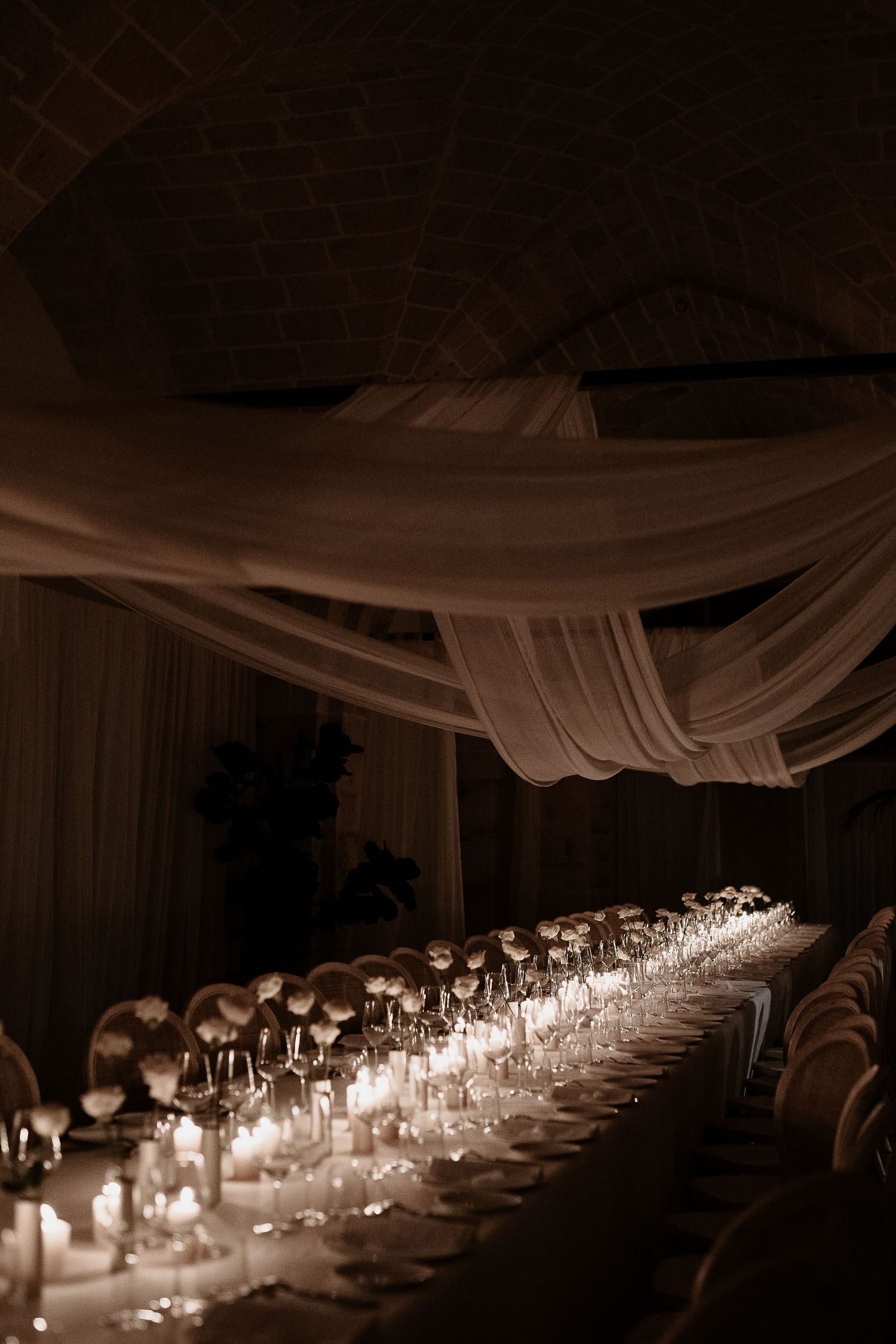 Candlelit imperial table with white fabric draping for a boutique Umbrian wedding. Shot by Gradisca Portento.