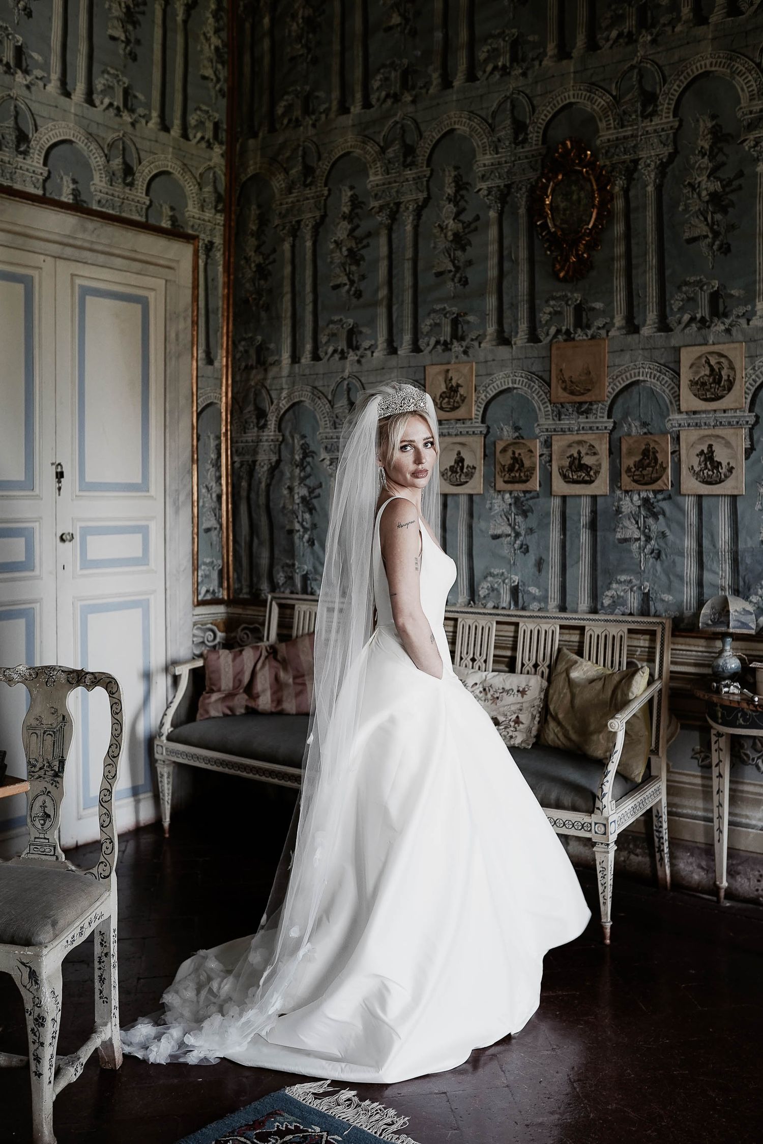 Elegant bride portrait in a historic Tuscan villa. Soft light captures the timeless beauty of her dress by Gradisca Portento.