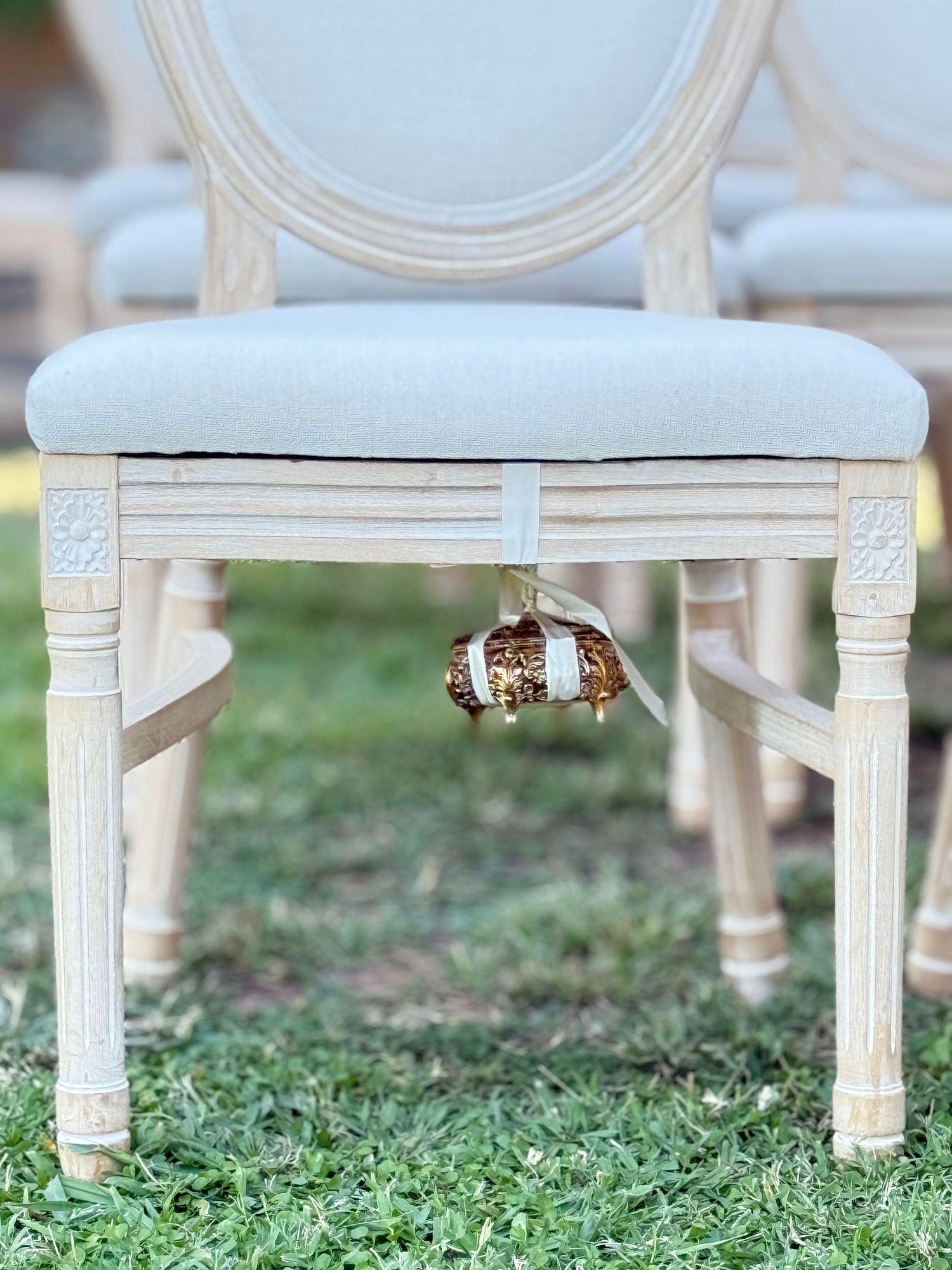 Behind the scenes wedding detail wedding rings in a box hidden beneath a vintage chair, captured on iPhone by Behind Wed wedding content