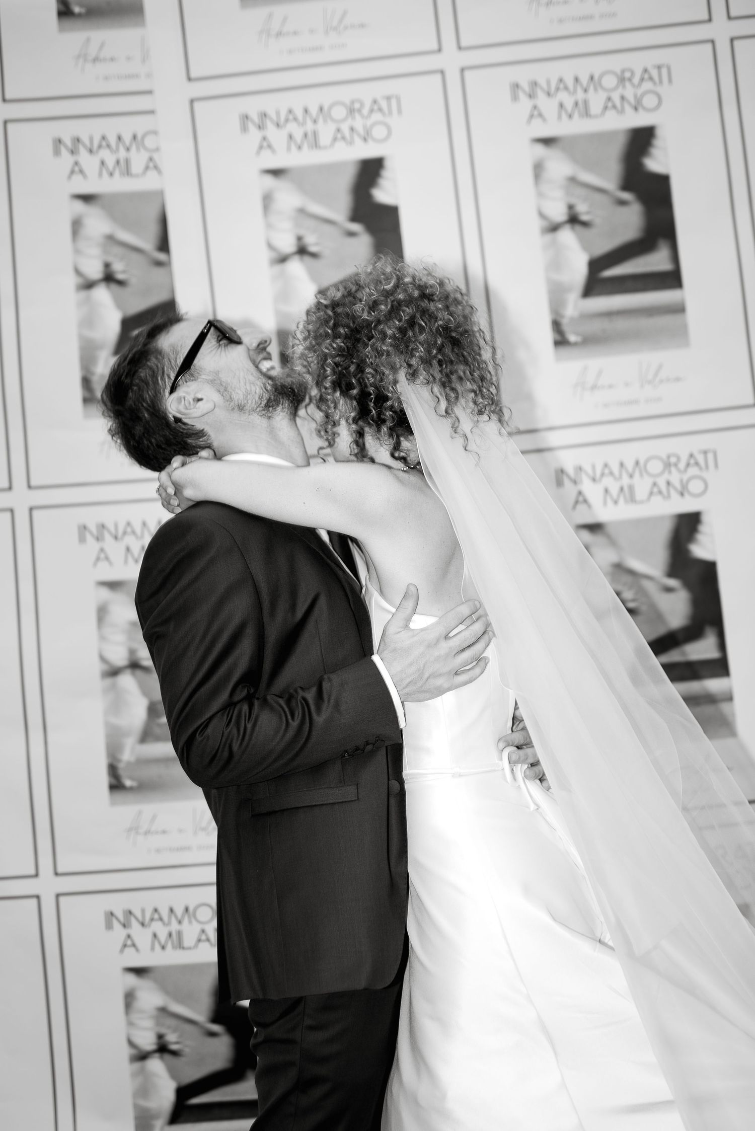 Editorial couple portrait by a chic photo wall. Modern and timeless wedding style by Gradisca Portento.