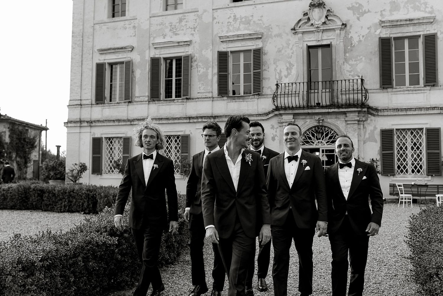 Groom and groomsmen walking in front Villa di Geggiano, capturing a candid, elegant intimate wedding in Tuscany photo by Gradisca Portento