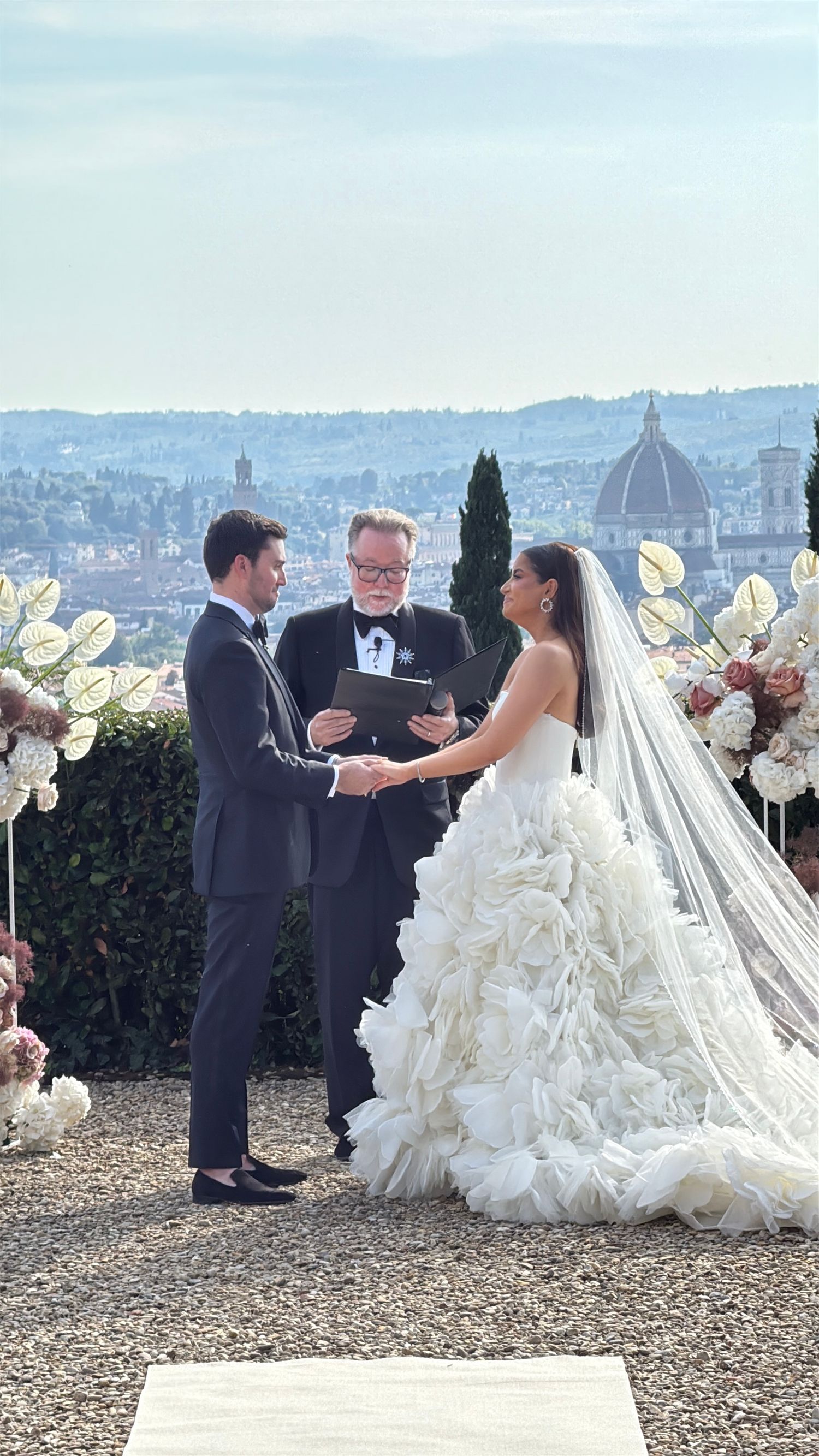 A cinematic iPhone photo of an elegant wedding ceremony overlooking the Florence skyline captured by Behind Wed Wedding Content Creator.
