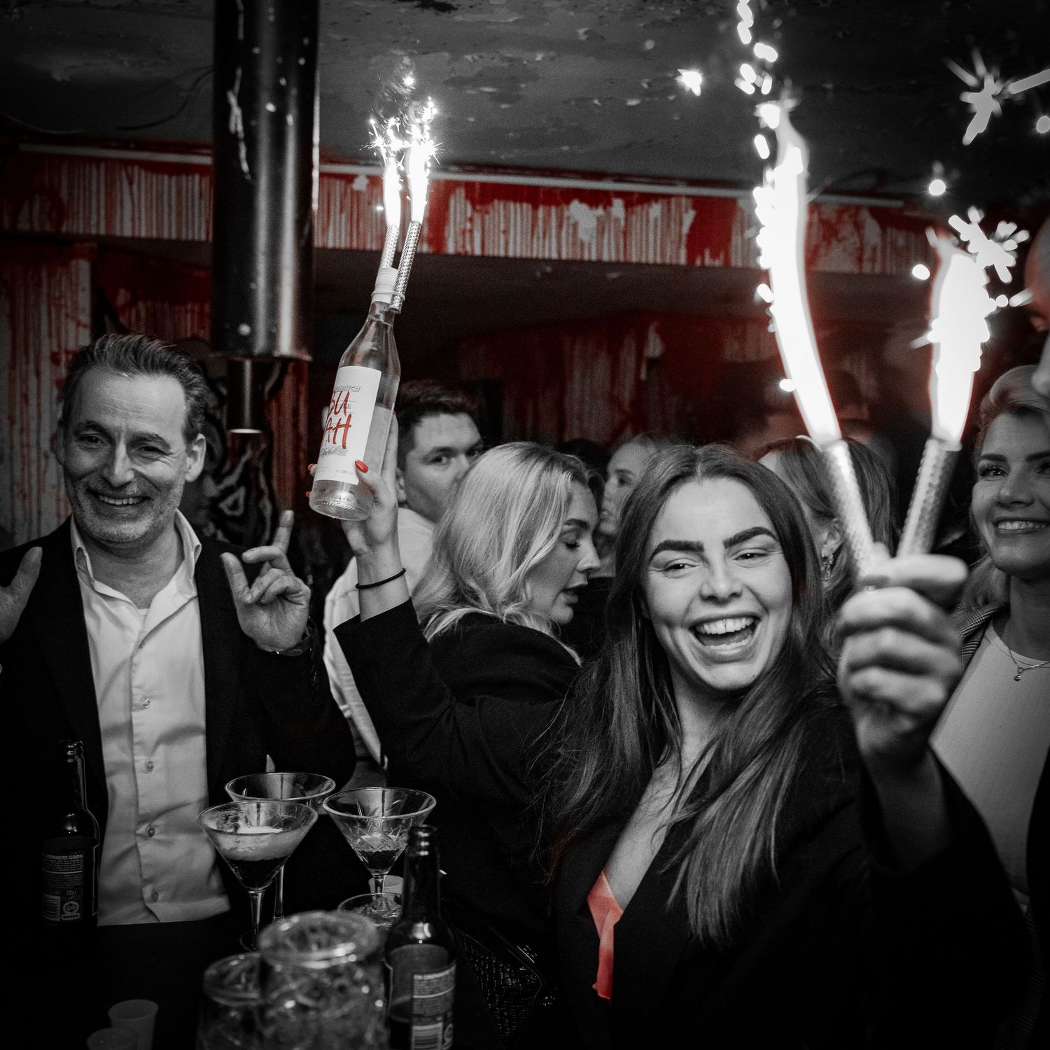 Festdeltagere fejrer med stjernekastere på et svagt oplyst sted.