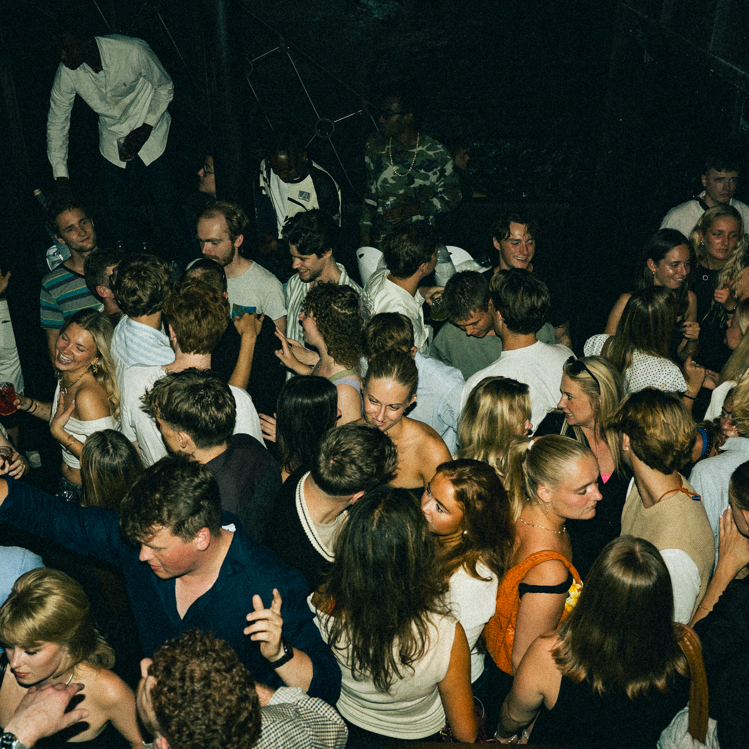A crowded nightclub dance floor filled with party-goers dancing and enjoying the vibrant atmosphere.