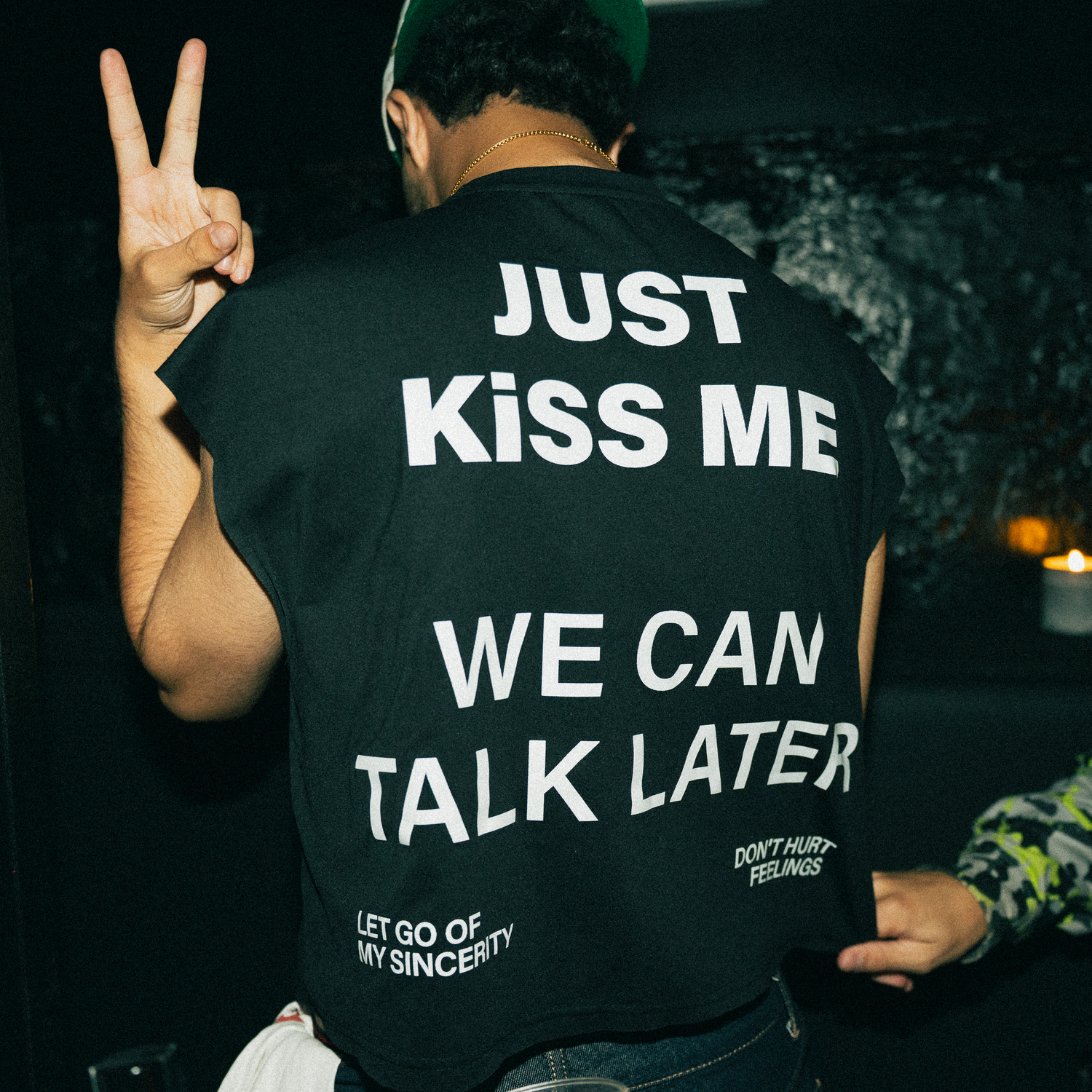 Collection of t-shirts with text messages displayed in dimly lit settings and multiple angles.