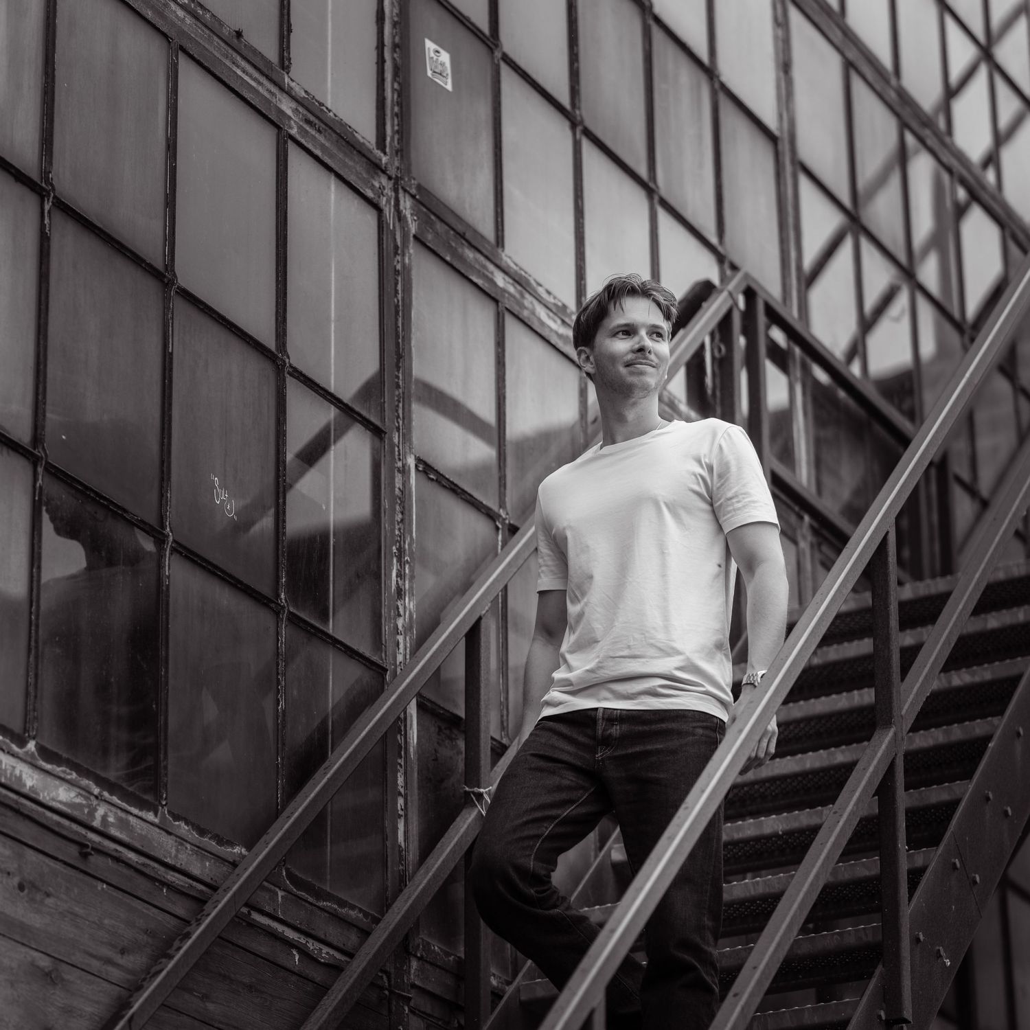 Black and white photo sequence showing an athlete performing a backflip off a structure or platform in an urban setting.