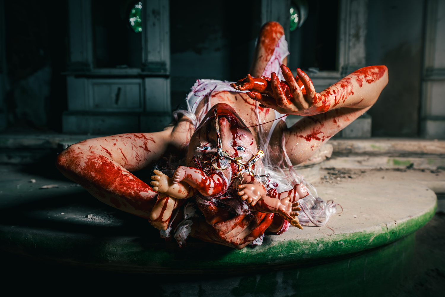 A knife cutting through raw meat on a green cutting board with blood visible in dim lighting.