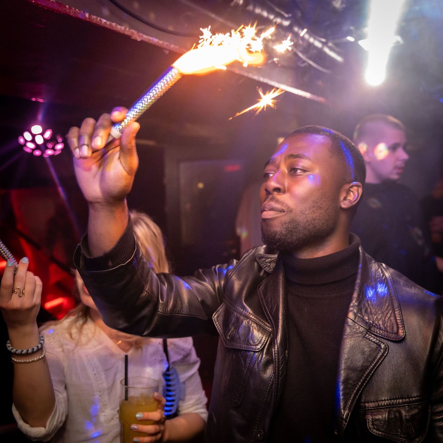 Person i læderjakke holder en stjernekaster i en natklub