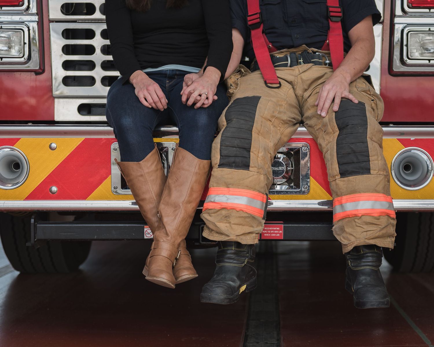 Cropped view of firefighter boots and casual boots sitting side by side on a fire truck.