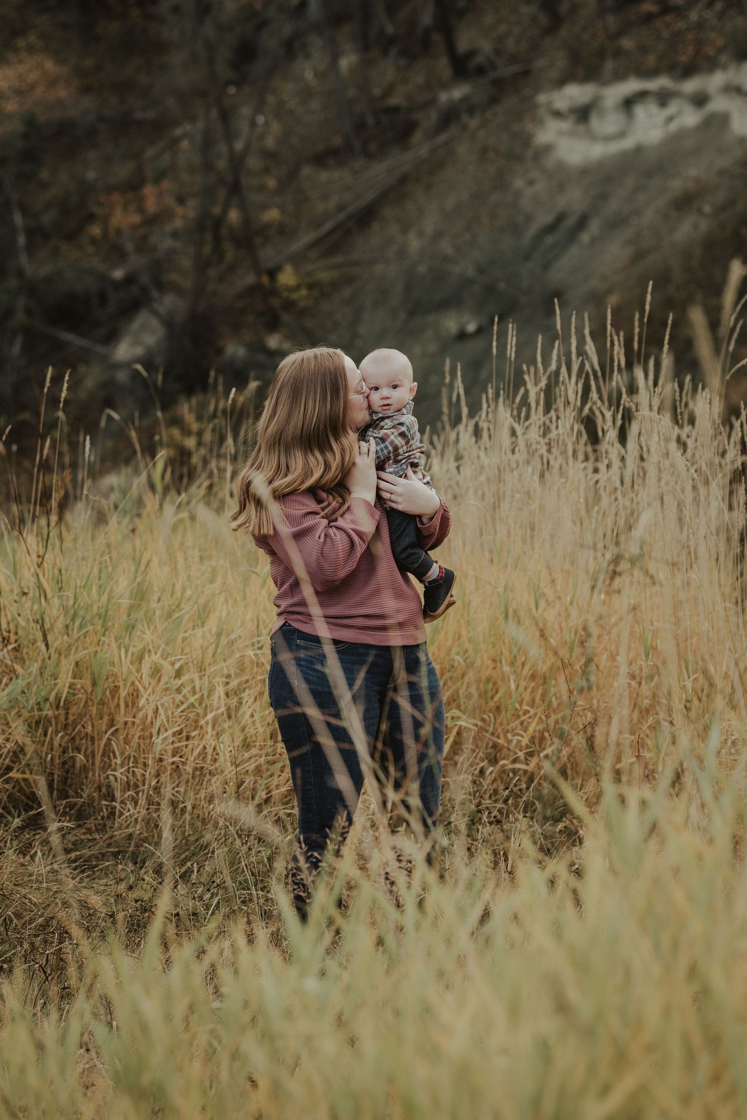 A tender moment between parent and child among tall autumn grasses.