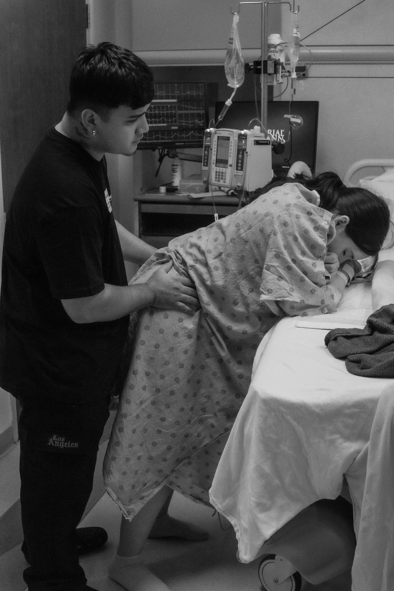 Hospital room scene showing care being provided in black and white.