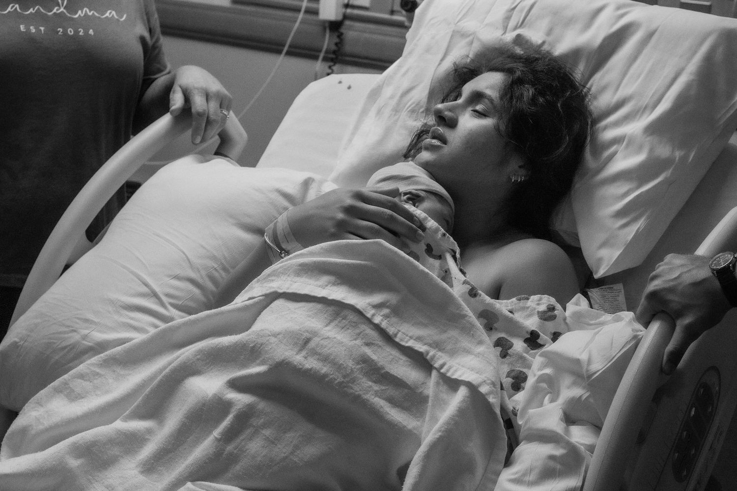 Patient resting in hospital bed with medical monitors attached.
