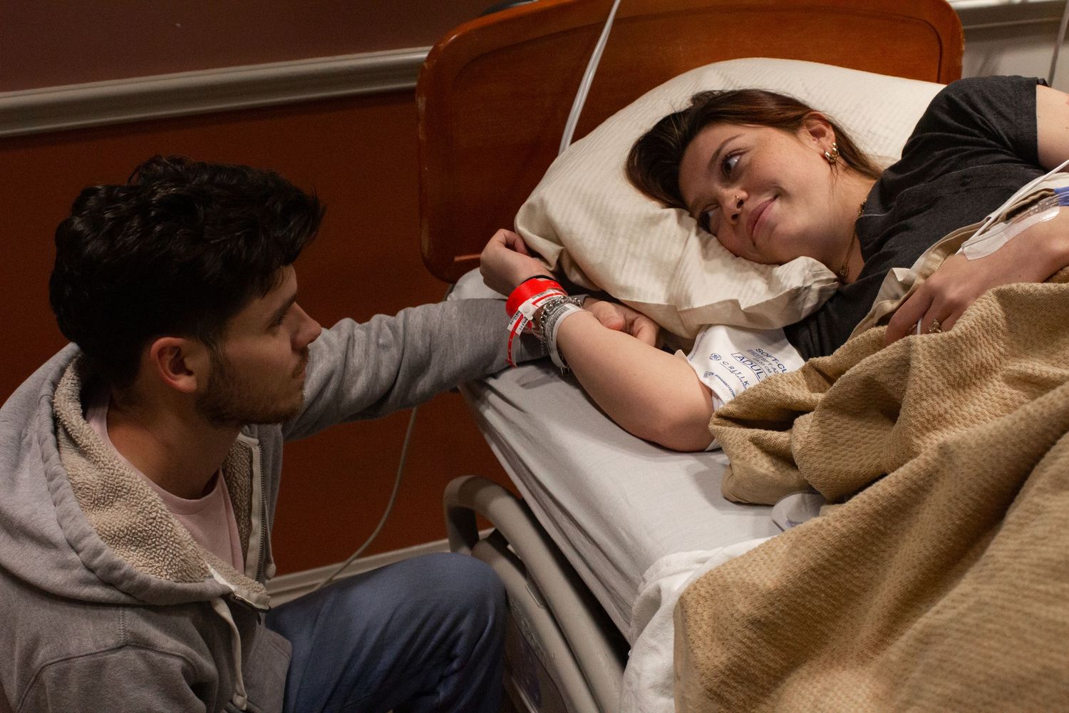 Patient receiving medical care while resting in a hospital bed.