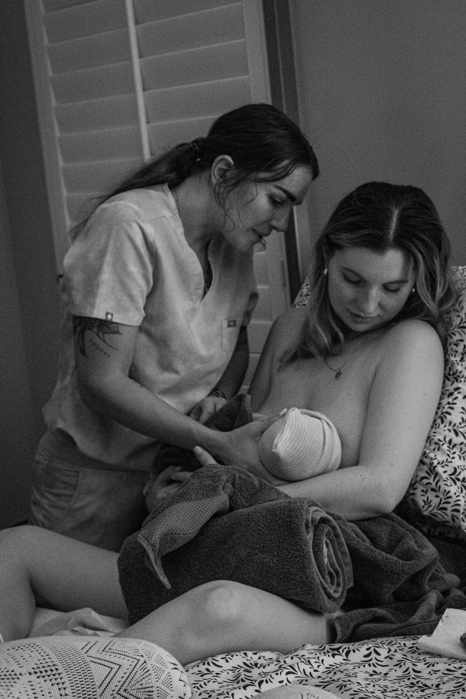 Healthcare provider assists with breastfeeding support in a calm setting.