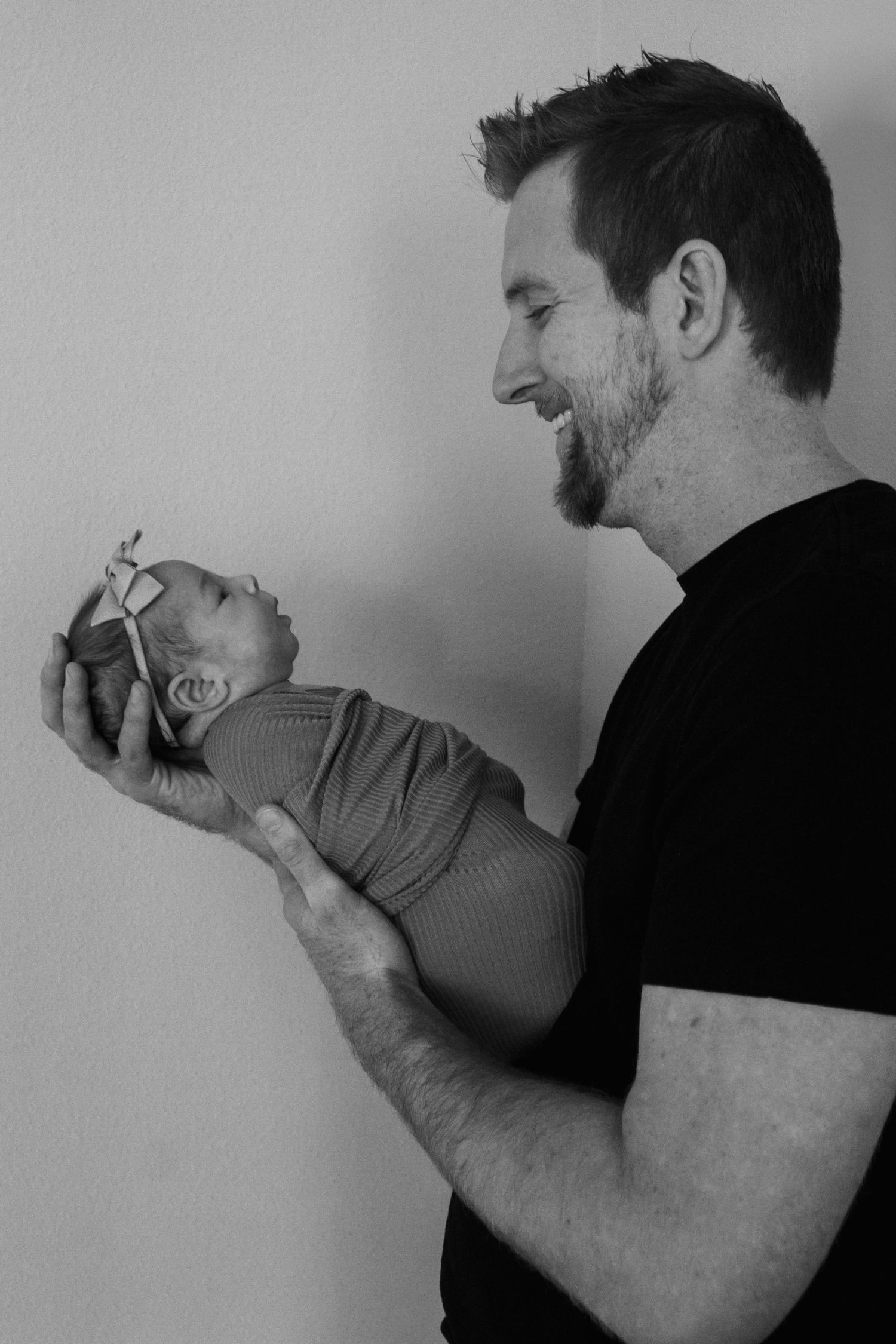 Black and white photo of adult holding tiny newborn.
