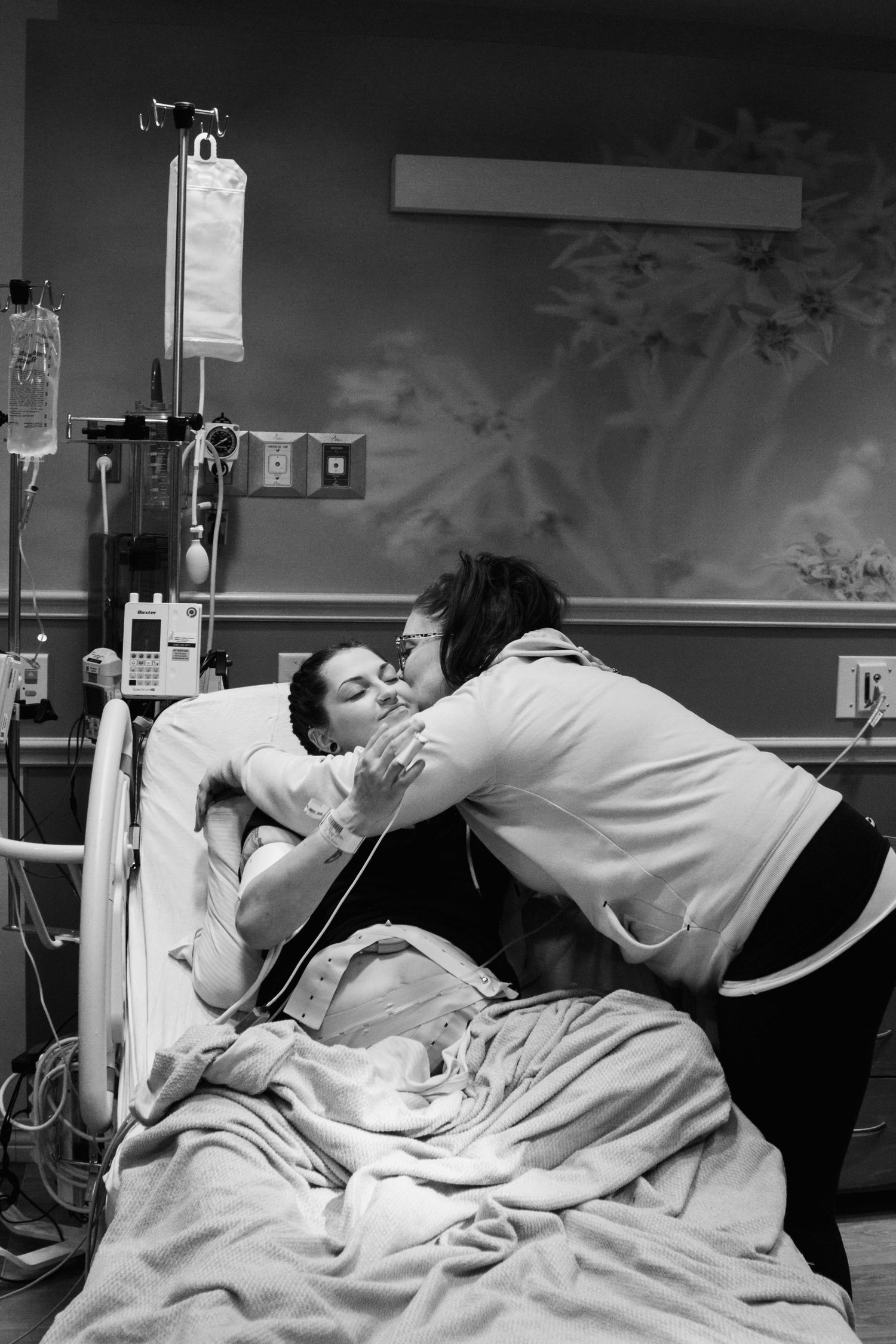 Black and white photo of an emotional moment in a hospital delivery room.