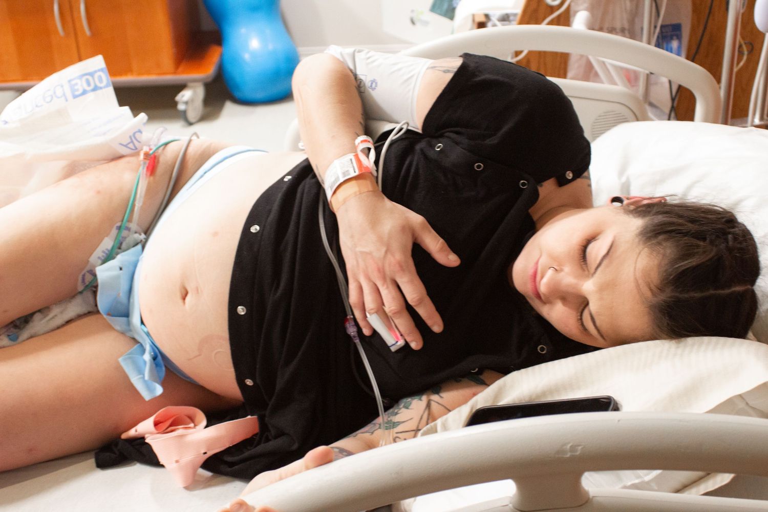 Pregnant person resting on hospital bed during labor.