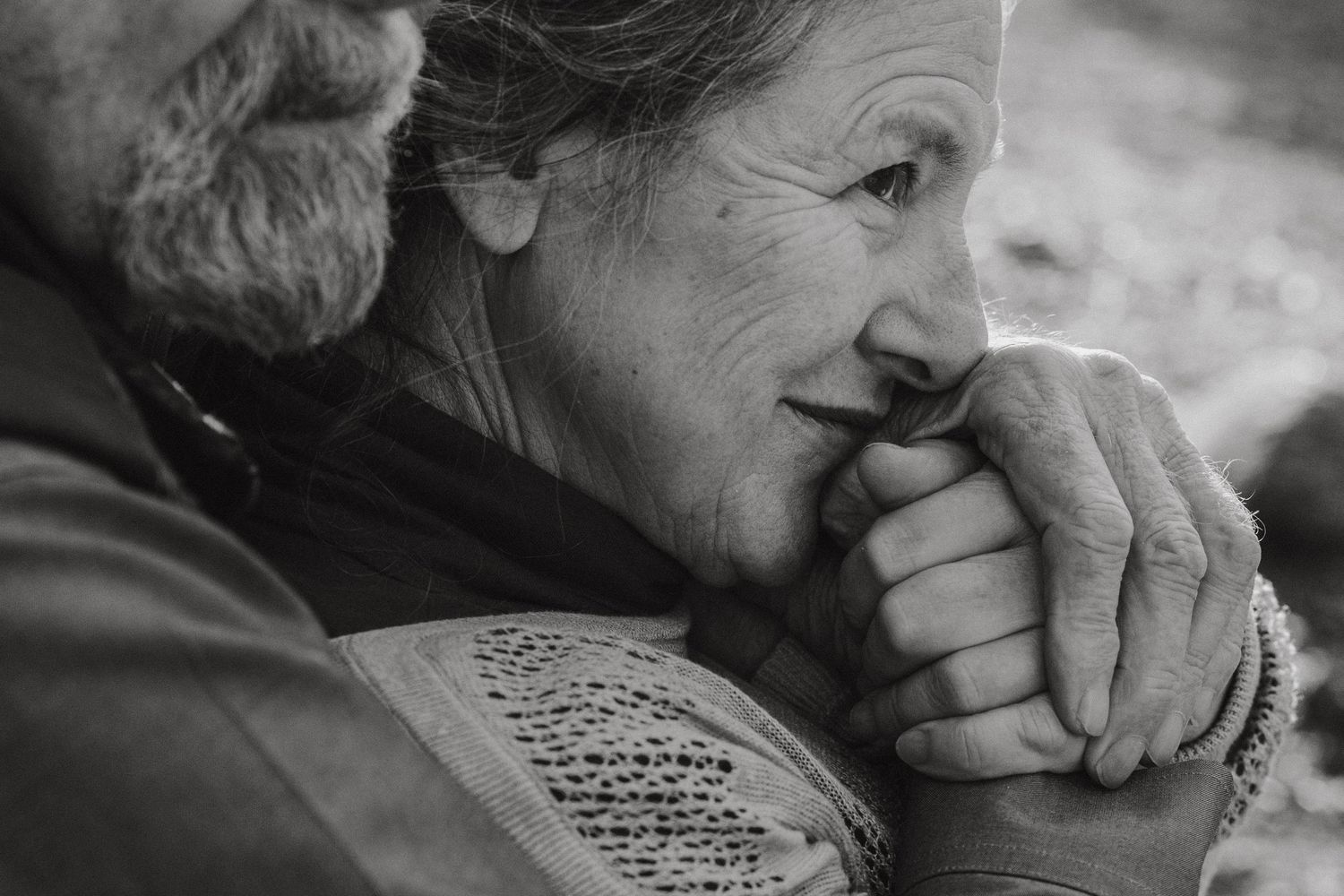 A contemplative moment captured in black and white with focus on weathered hands.