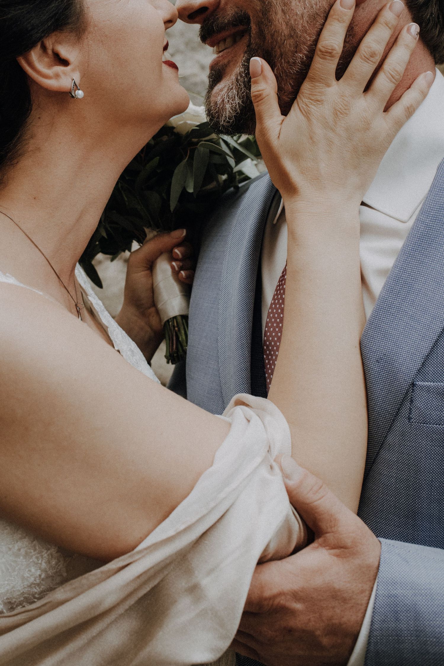 A romantic wedding moment captured in close-up showing tender embrace between newlyweds.