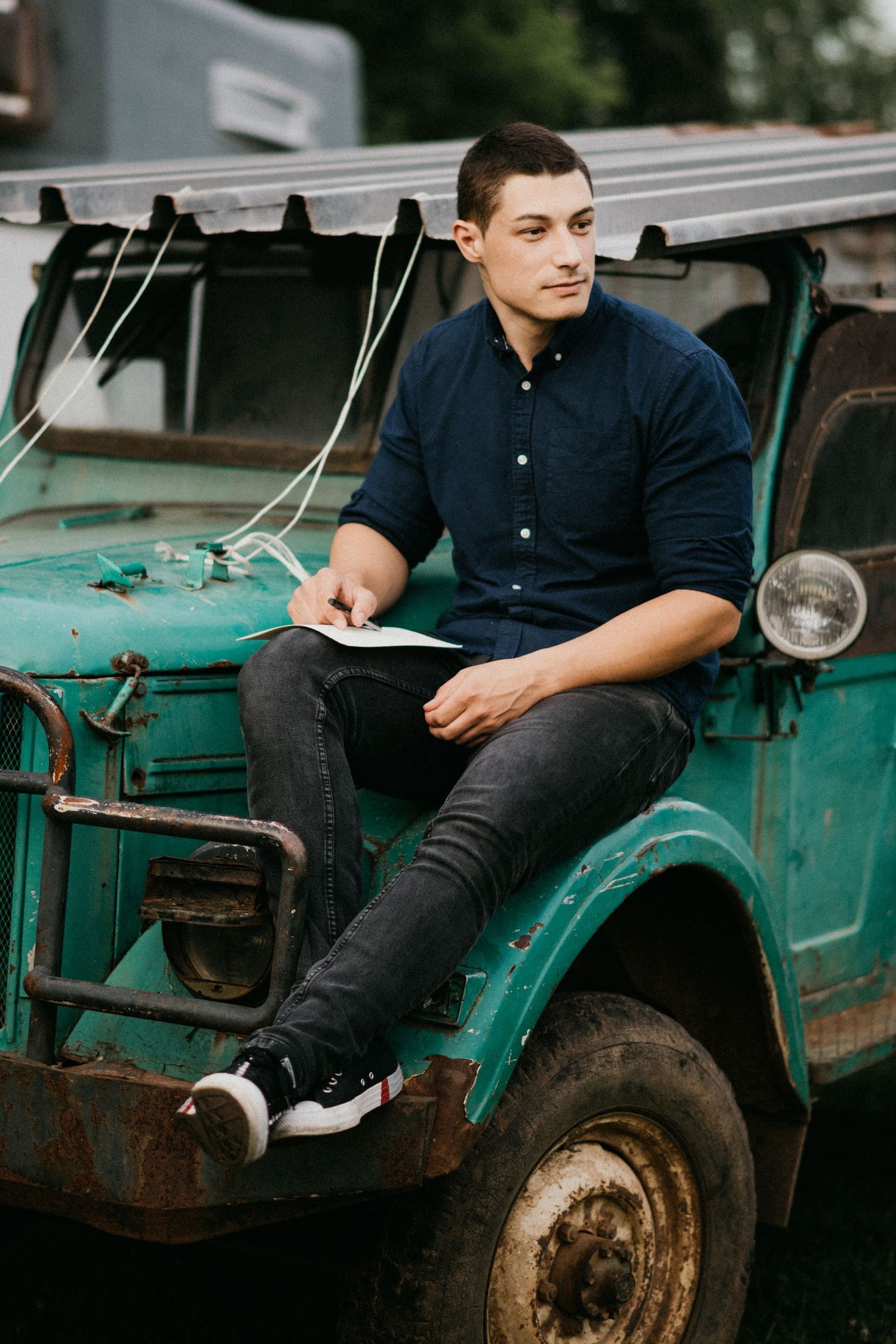 Vintage turquoise truck serves as backdrop for a casual outdoor portrait.