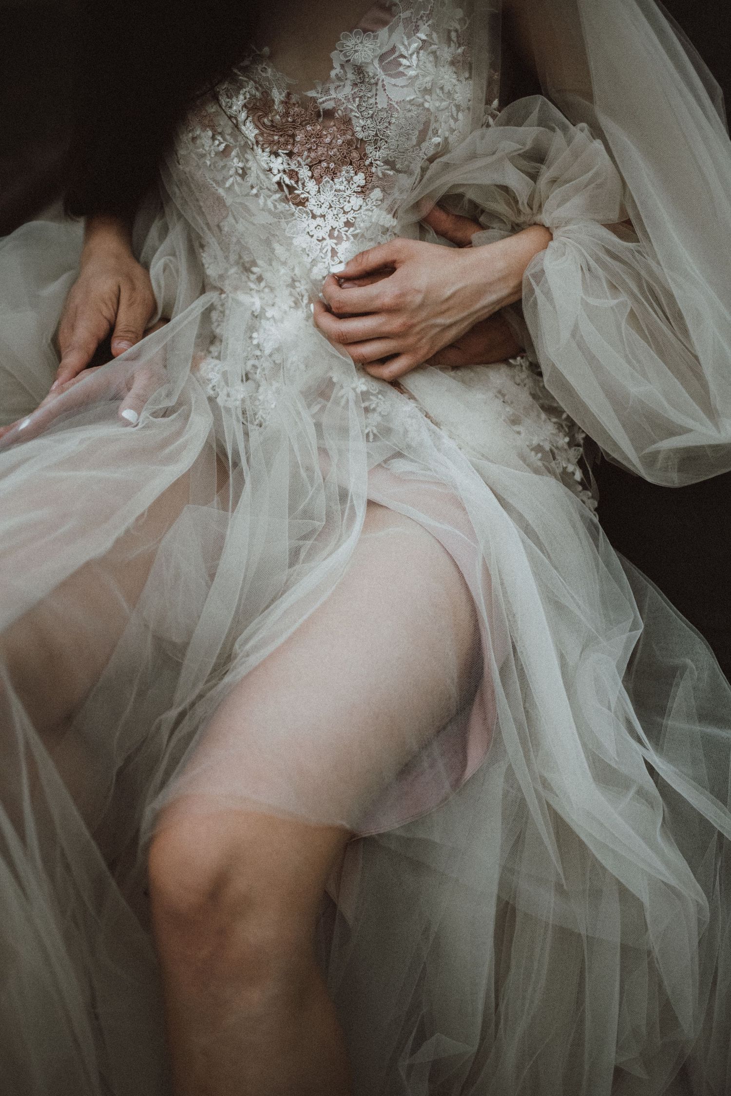 Ethereal closeup of a wedding dress with delicate lace and tulle details.