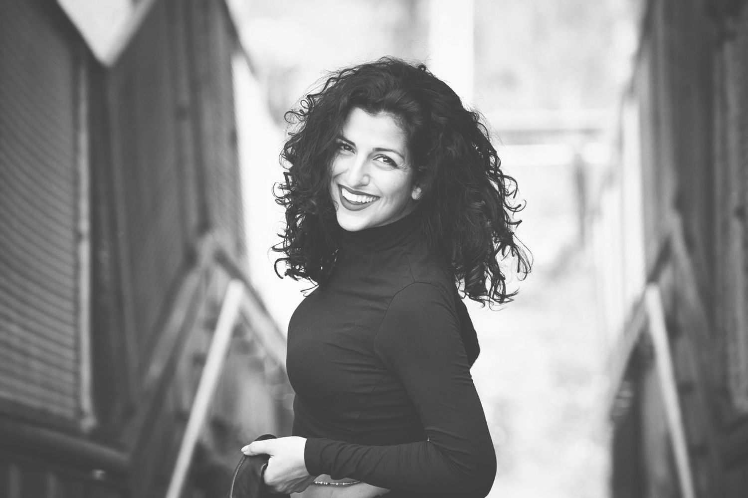 A black and white portrait series shows a person with curly hair wearing dark clothing against a light background.