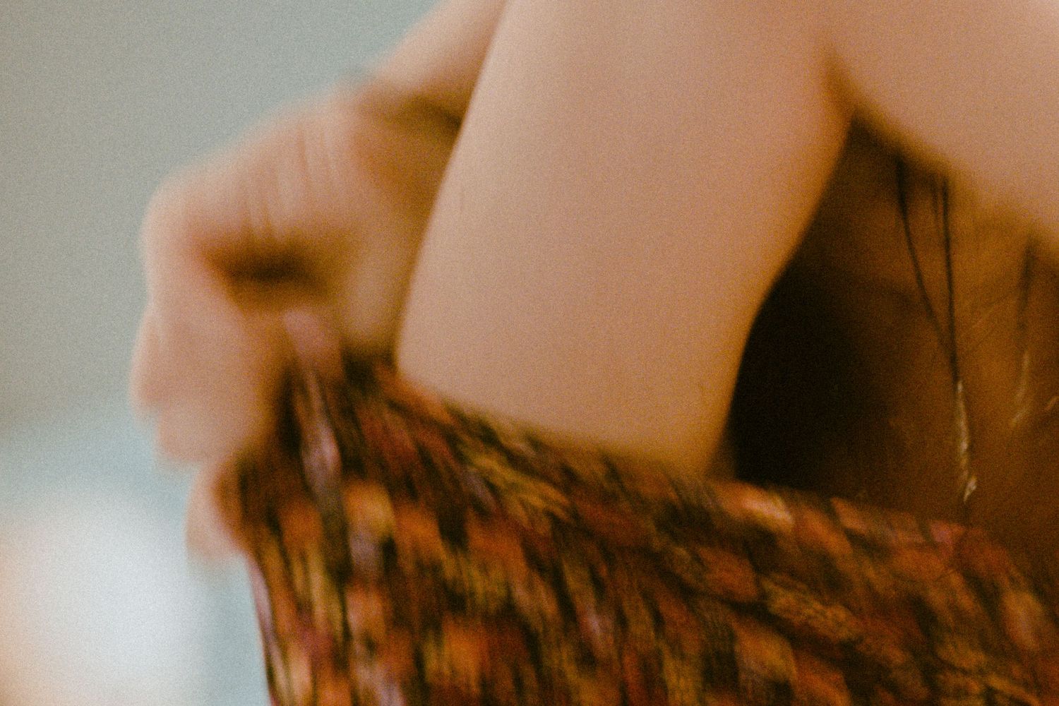 Close-up abstract shot of textured fabric or material in soft warm tones.