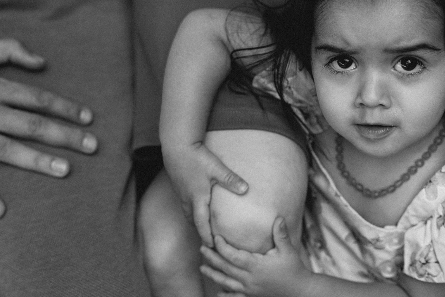 A tender black and white photo showing gentle touch and an innocent expression in an intimate close-up portrait.