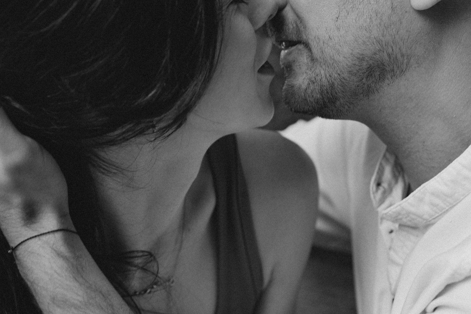 A close up black and white photo showing two people about to kiss in an intimate romantic moment.