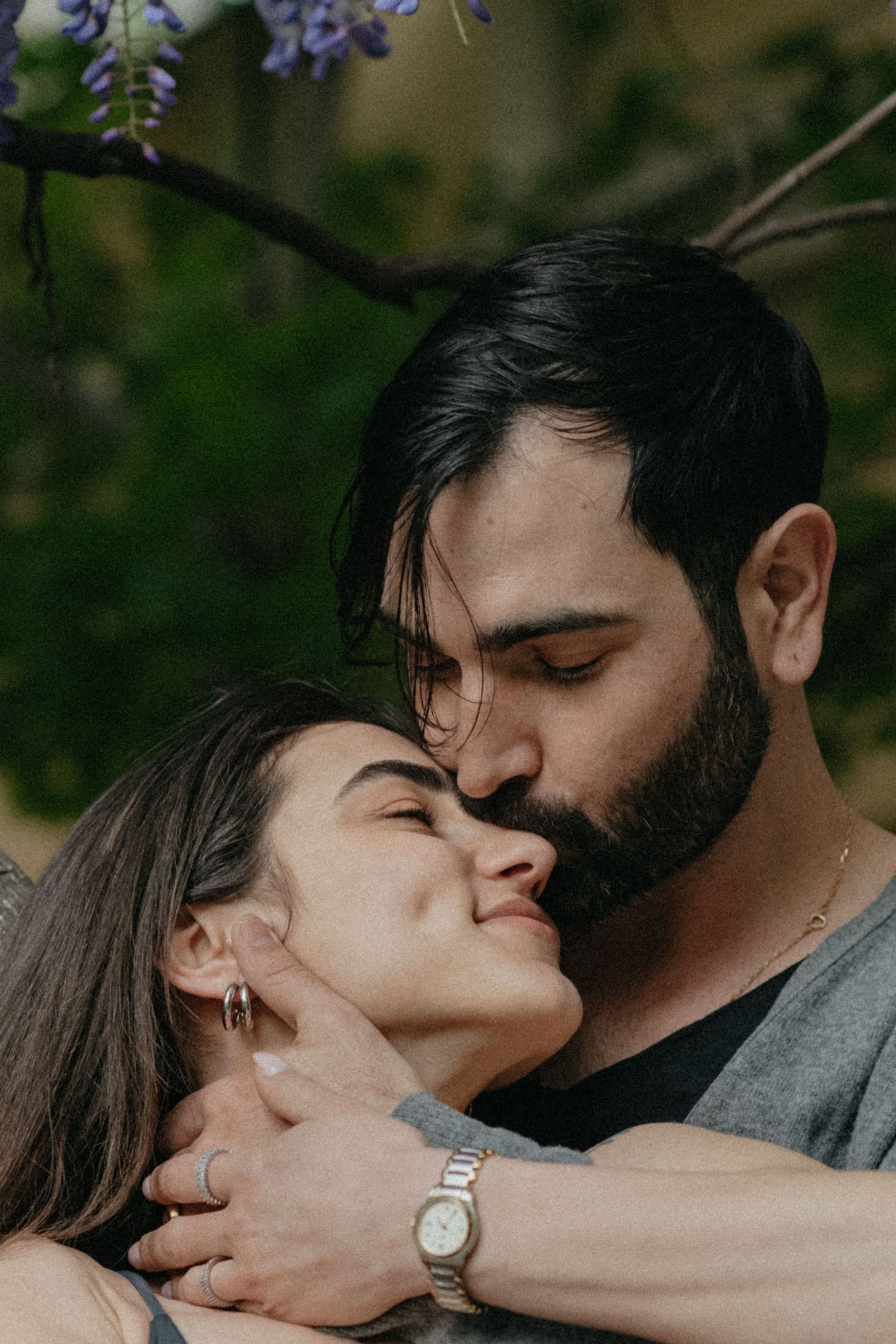 Romantic couple sharing an intimate moment outdoors among flowers.