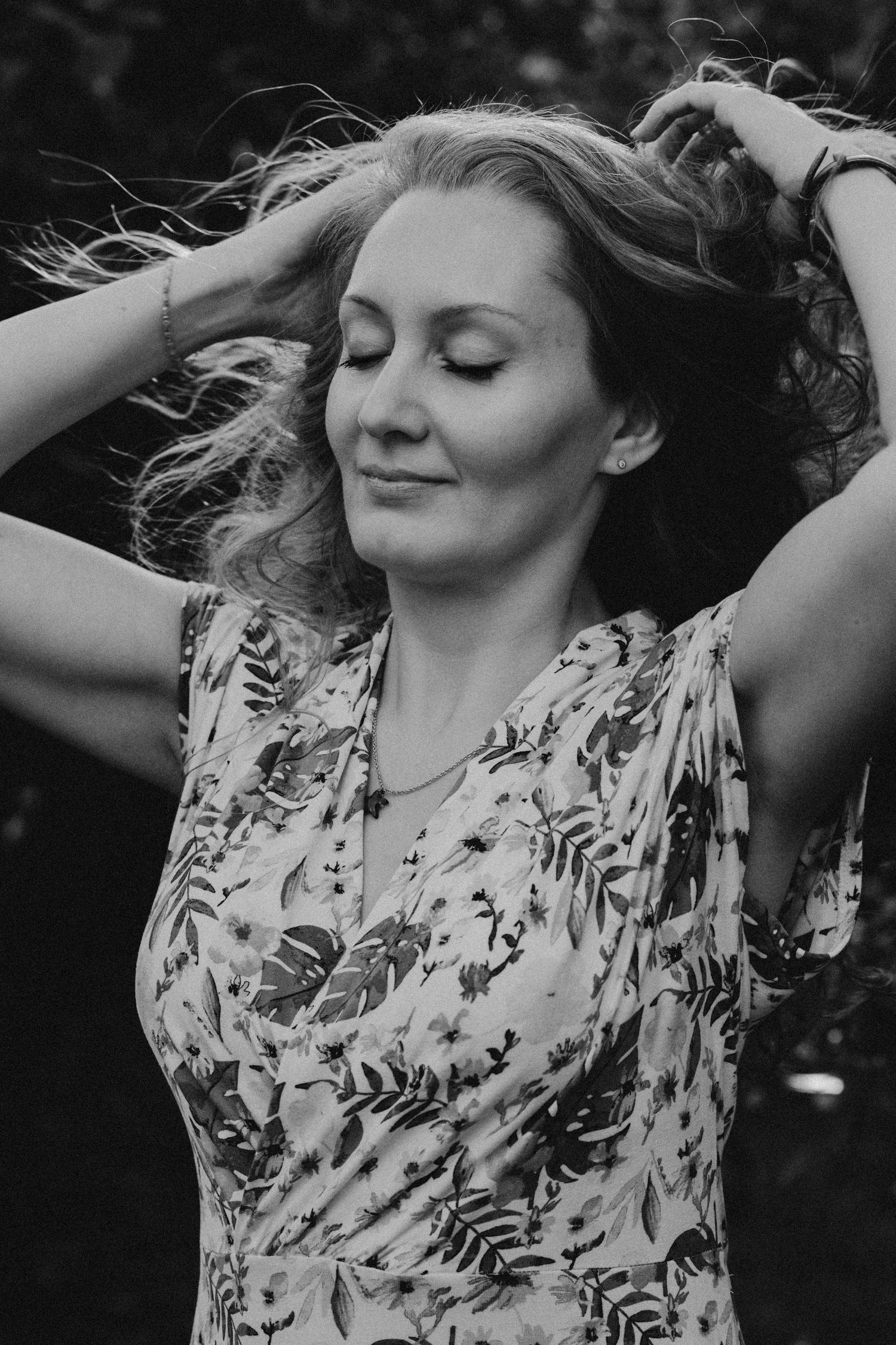 Black and white series of a person in a floral dress dancing with flowing movement.