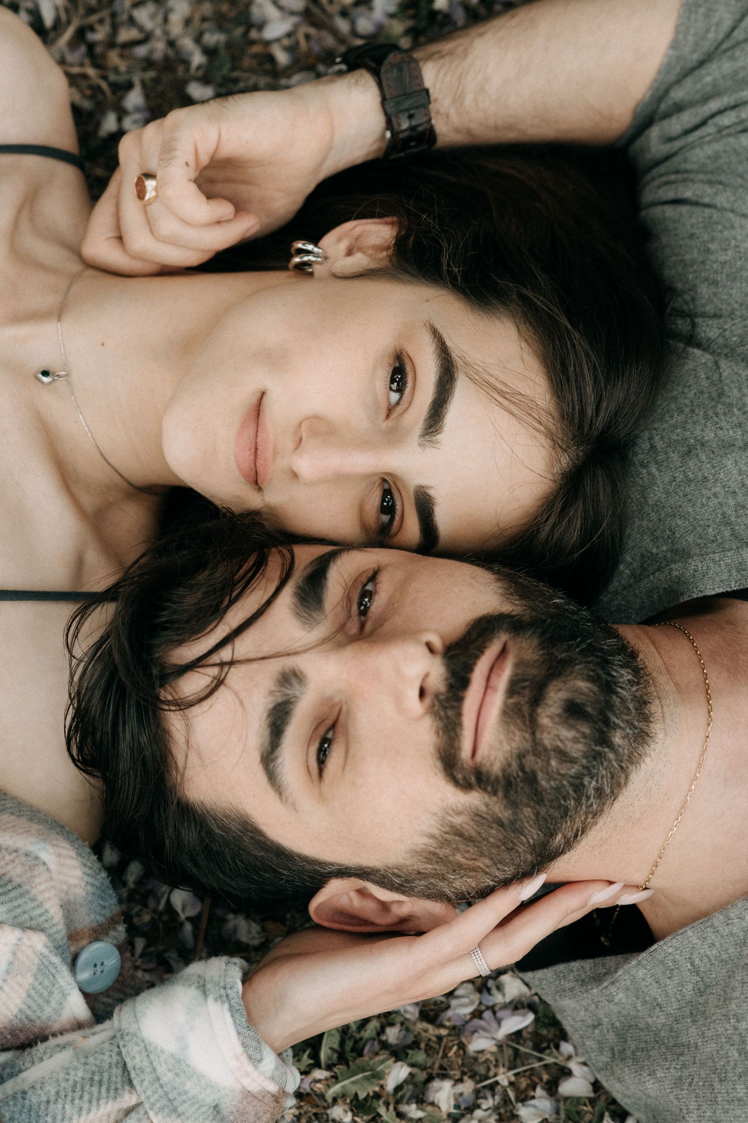Couple lying together on autumn leaves in an artistic portrait session.