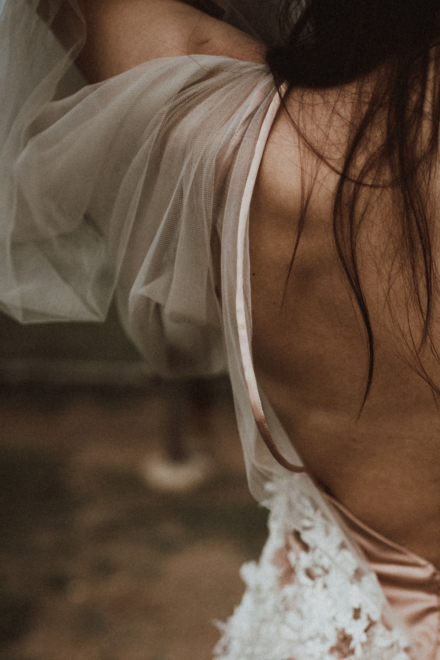 Delicate white bridal dress detail with sheer fabric and lace detailing.