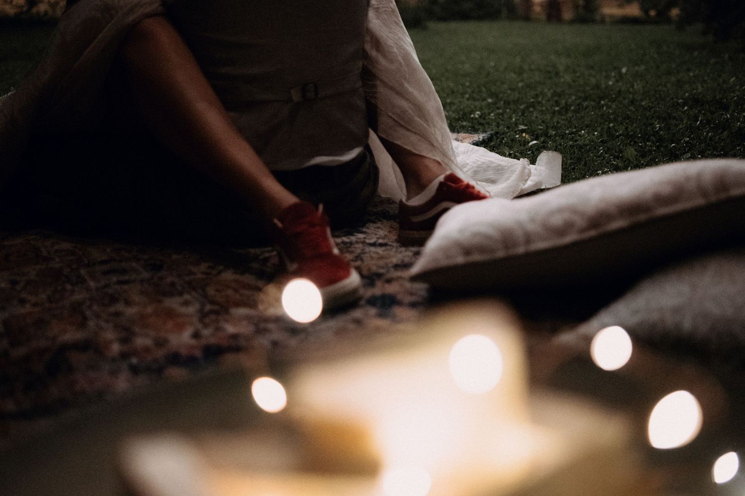 Atmospheric evening scene with glowing lights on the ground and feet in frame.