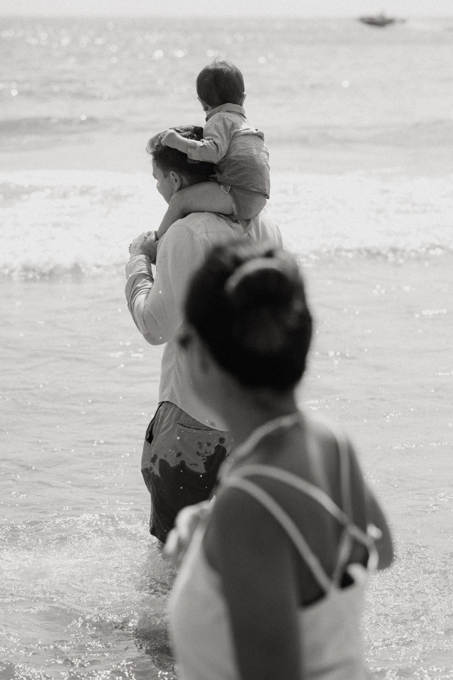 Black and white beach scene showing people playing in the waves.